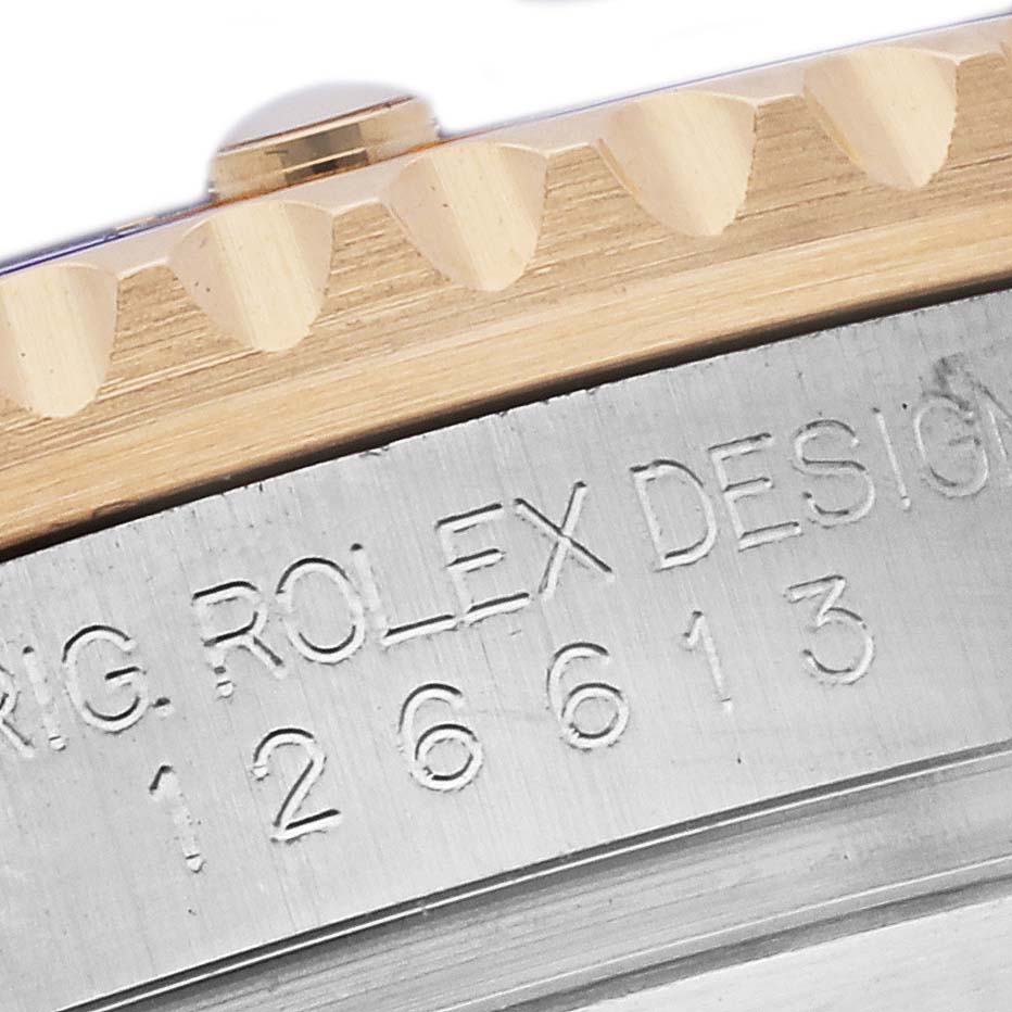 The image shows a close-up of the side of a Rolex Submariner 126613 Men's Steel and Gold (two tone) Blue Dial 126613 Men's Steel and Gold (two tone) Blue Dial, highlighting the bezel teeth and etched model number.