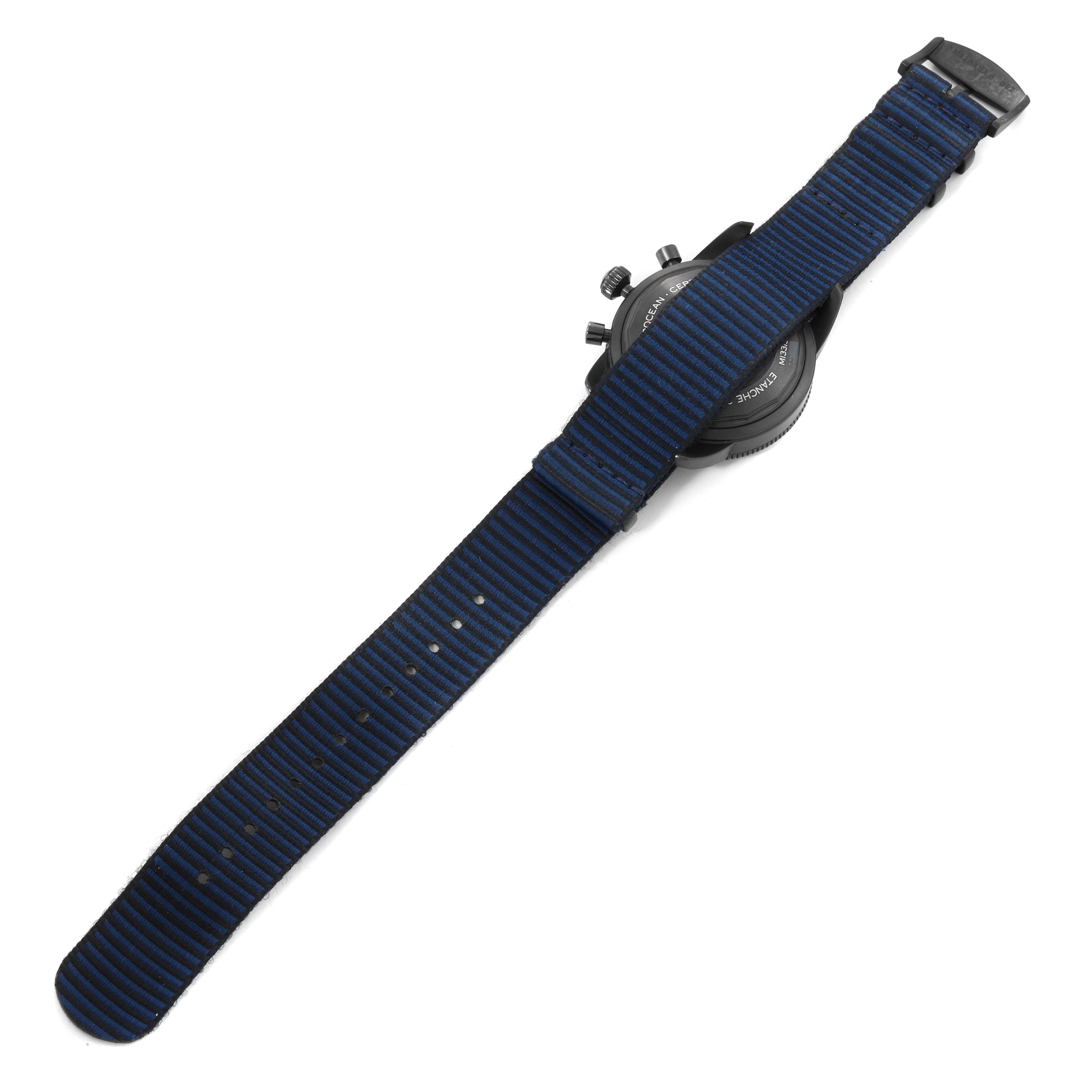 The image shows the back side of a Breitling Superocean M13313 Men's Stainless Steel Blue Dial M13313 Men's Stainless Steel Blue Dial watch with a blue and black striped fabric strap.