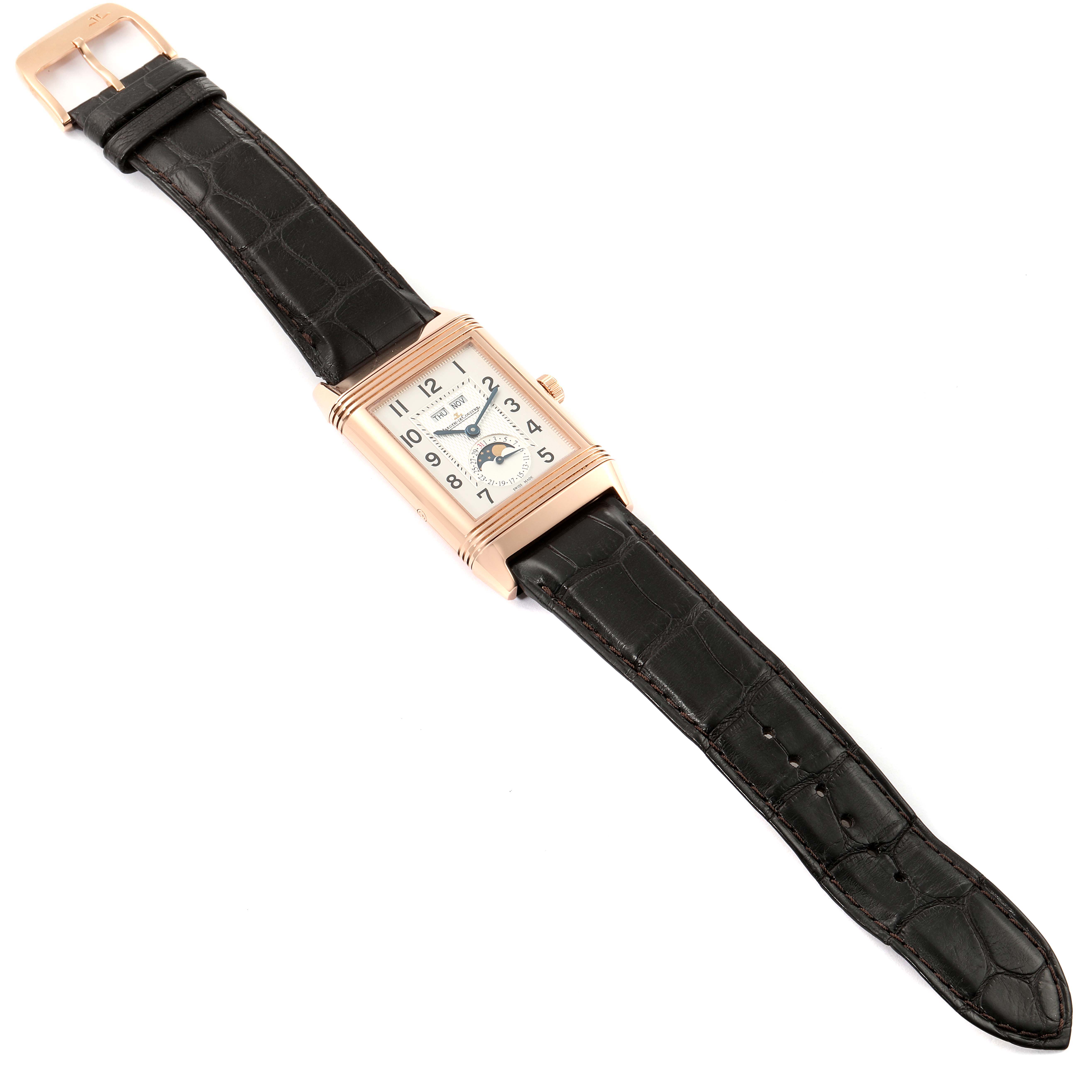 The image shows a Jaeger-LeCoultre Reverso watch laid flat, displaying its rectangular dial and black leather strap.