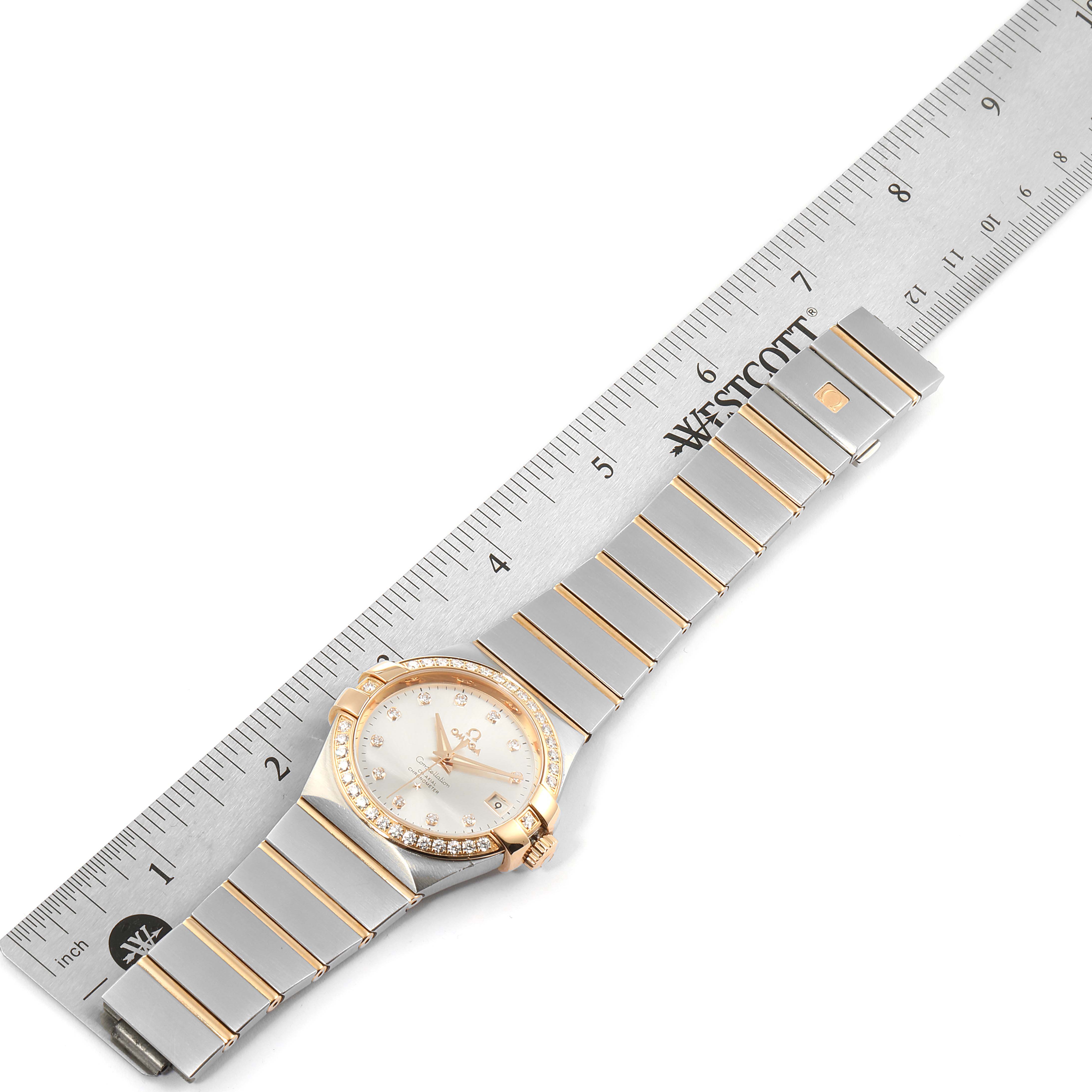 The image shows an Omega Constellation 123.25.35.20.52.001 Men's Stainless Steel Silver Dial 123.25.35.20.52.001 Men's Stainless Steel Silver Dial watch measured against a ruler, displaying its face, bezel, and bracelet.