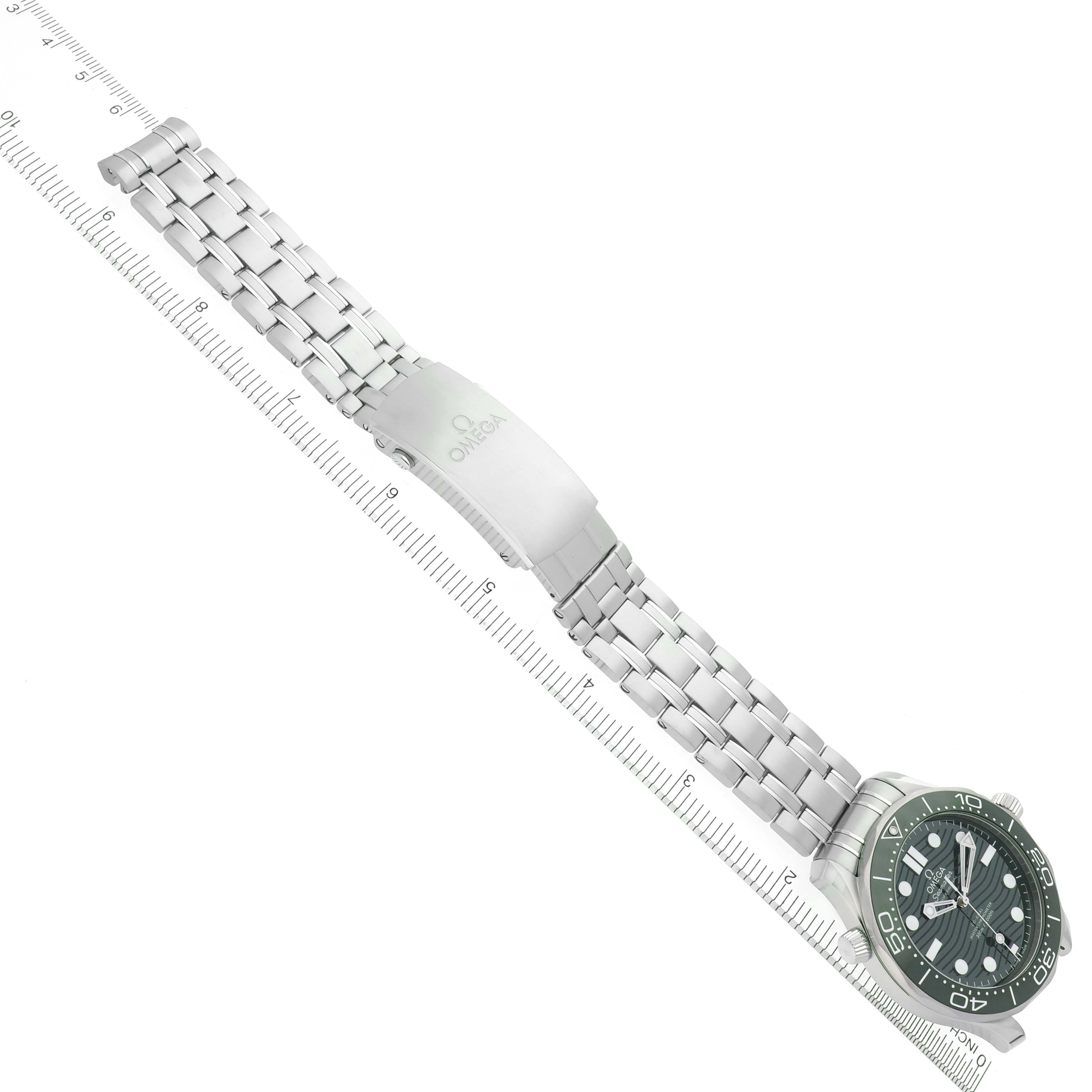 The image shows an Omega Seamaster 210.30.42.20.10.001 Men's Stainless Steel Green Dial 210.30.42.20.10.001 Men's Stainless Steel Green Dial watch at a diagonal angle, displaying the full bracelet and clasp aligned with a ruler.