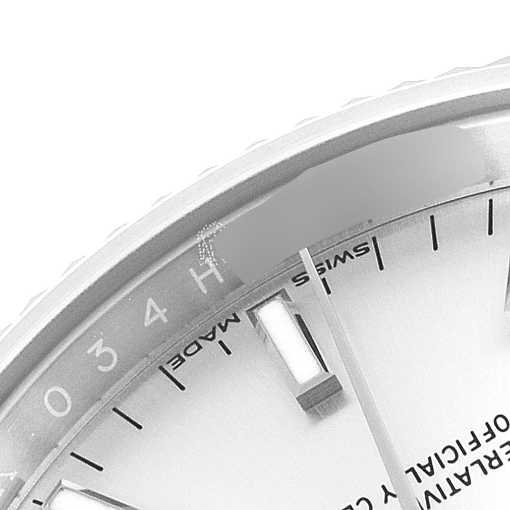 The image shows a close-up of a partial dial and bezel of a Rolex Date 115234 Men's Stainless Steel Silver Dial 115234 Men's Stainless Steel Silver Dial model watch.