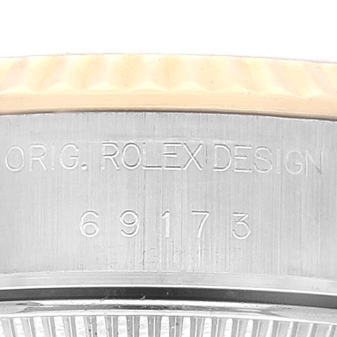 The image shows the side profile of a Rolex Datejust 69173 Women's Steel and Gold (two tone) Champagne Dial 69173 Women's Steel and Gold (two tone) Champagne Dial model, highlighting the bezel and engraved serial number.