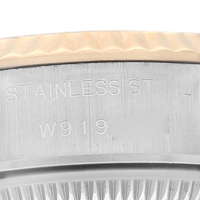This close-up image shows the side of the stainless steel case of a Rolex Datejust 69173 Women's Steel and Gold (two tone) Champagne Dial 69173 Women's Steel and Gold (two tone) Champagne Dial watch, including part of the fluted bezel and a serial number.
