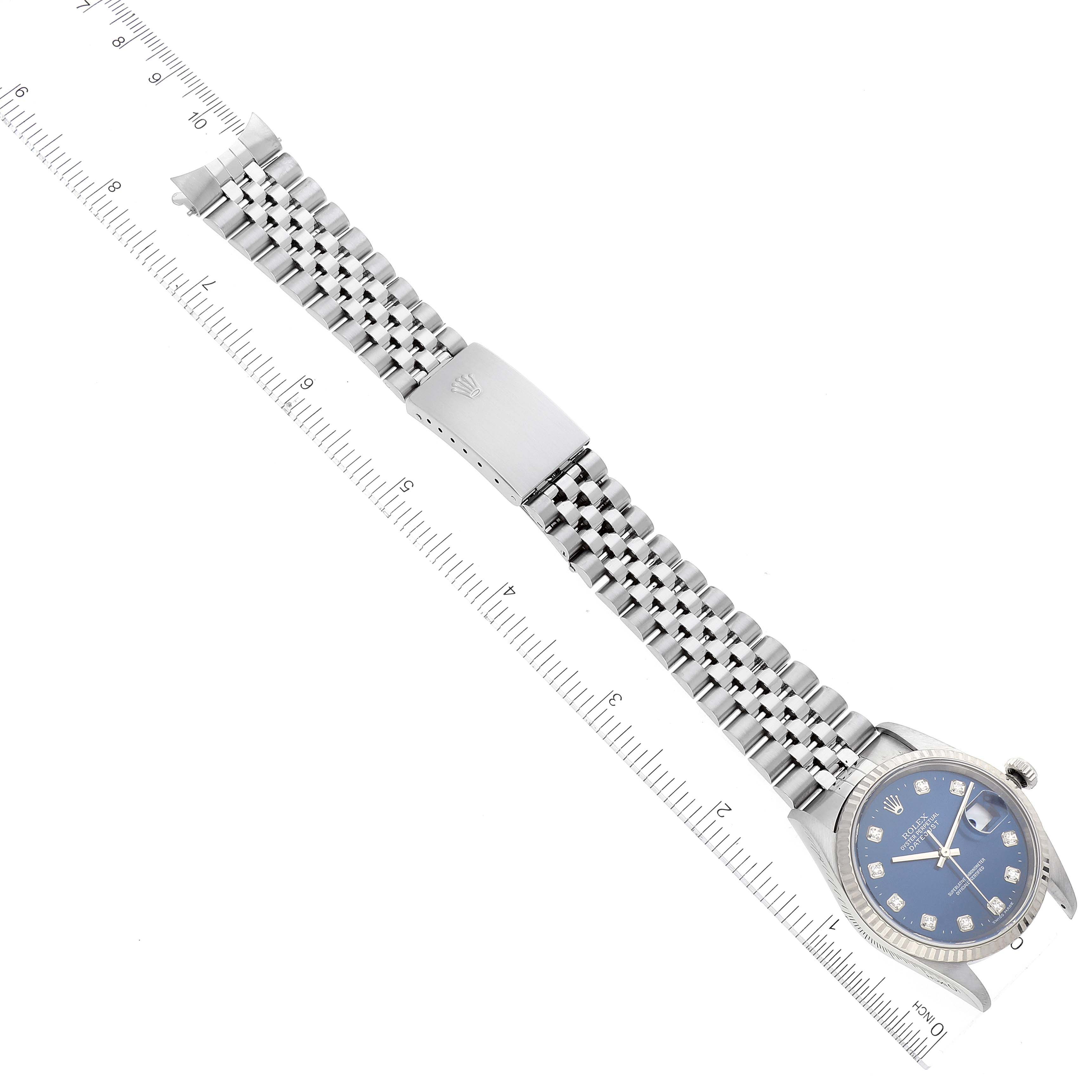 This image shows a Rolex Datejust 16234 Men's Stainless Steel Blue Dial 16234 Men's Stainless Steel Blue Dial watch laid flat, displaying the face, bezel, and bracelet with a clasp, along with a ruler for size reference.