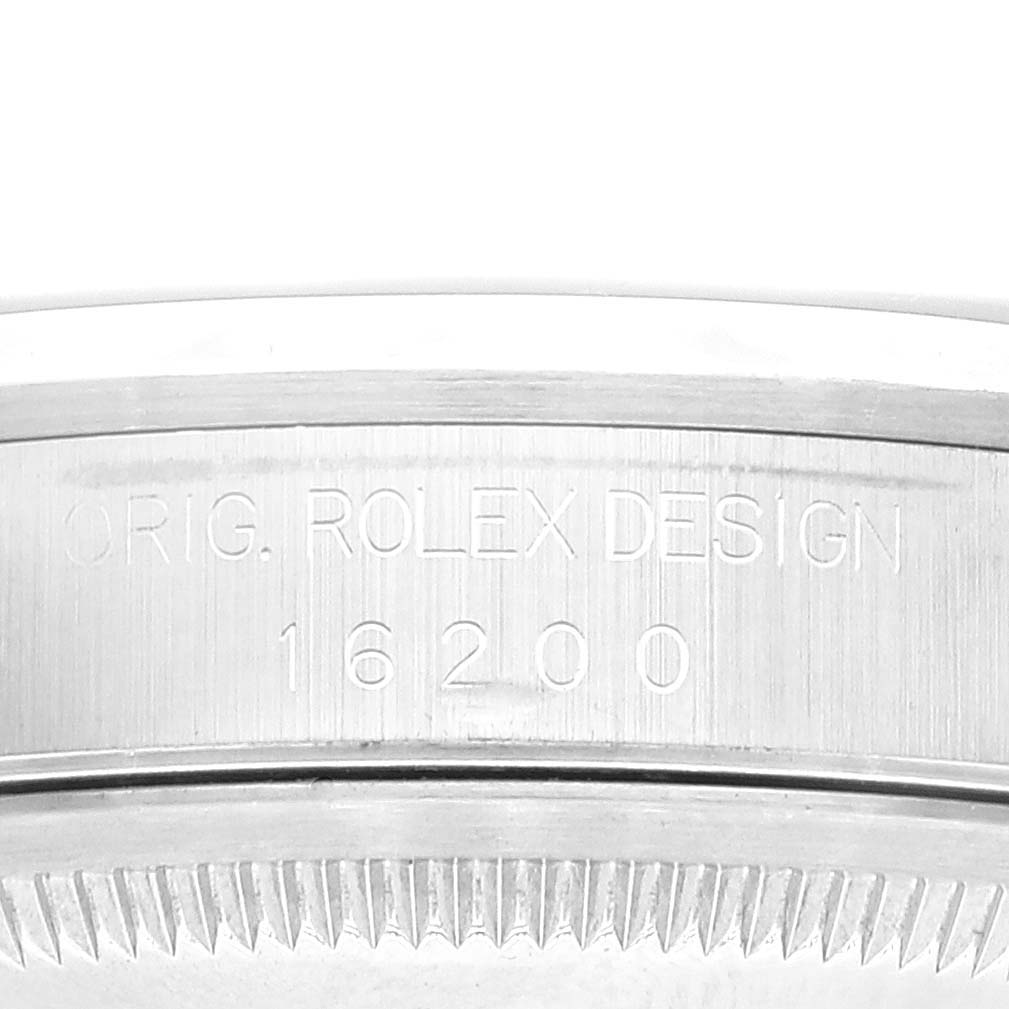This image shows a close-up of the side of a Rolex Datejust 16200 Men's Stainless Steel Blue Dial 16200 Men's Stainless Steel Blue Dial watch case with the engraving "ORIG. ROLEX DESIGN 16200."