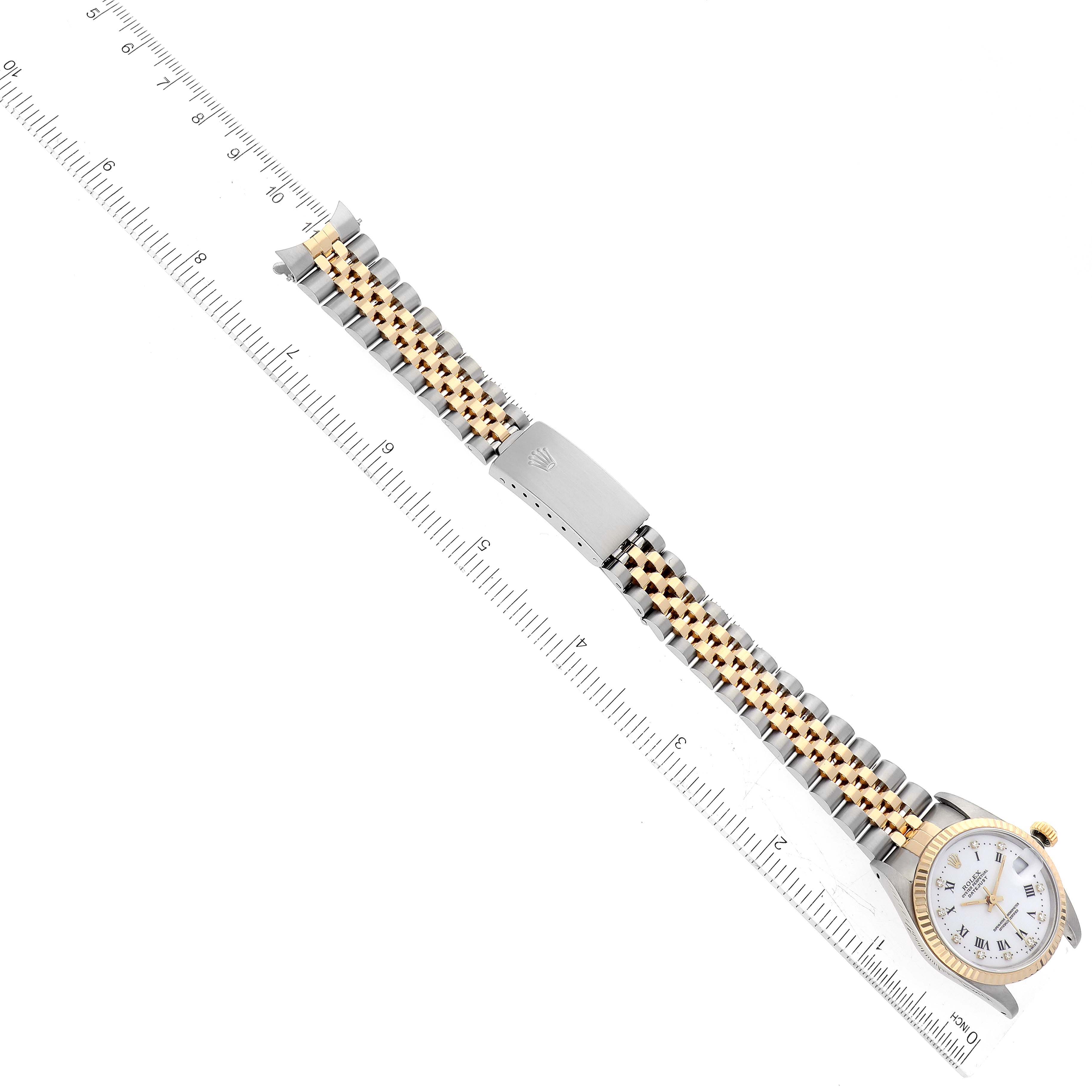 The image shows a complete Rolex Mid-Size 68273 Women
s Steel and Gold (two tone) White Dial 68273 Women
s Steel and Gold (two tone) White Dial watch with a bi-metal strap and clasp, placed alongside a millimeter ruler.