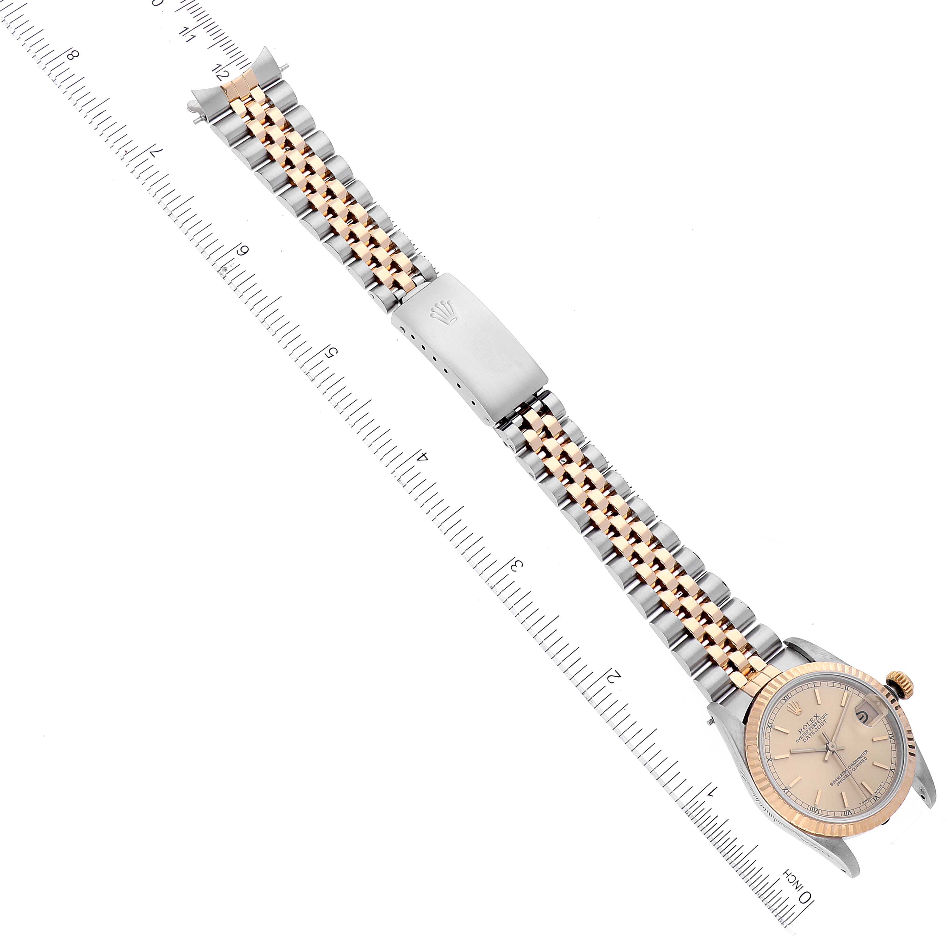The image shows a Rolex Mid-Size 68273 Women
s Steel and Gold (two tone) Champagne Dial 68273 Women
s Steel and Gold (two tone) Champagne Dial model watch laid flat, displaying the whole band and watch face, aligned next to a ruler for measurement.