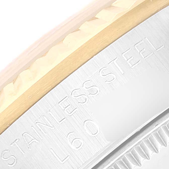 The image shows a close-up of the bezel and part of the case back of a Mid-Size Rolex watch, highlighting the "Stainless Steel" engraving.