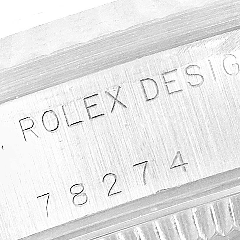 The image shows a close-up of the engraved serial number and "ROLEX DESIGN" text on the Rolex Mid-Size 78274 Women
s Stainless Steel Silver Dial 78274 Women
s Stainless Steel Silver Dial watch casing.