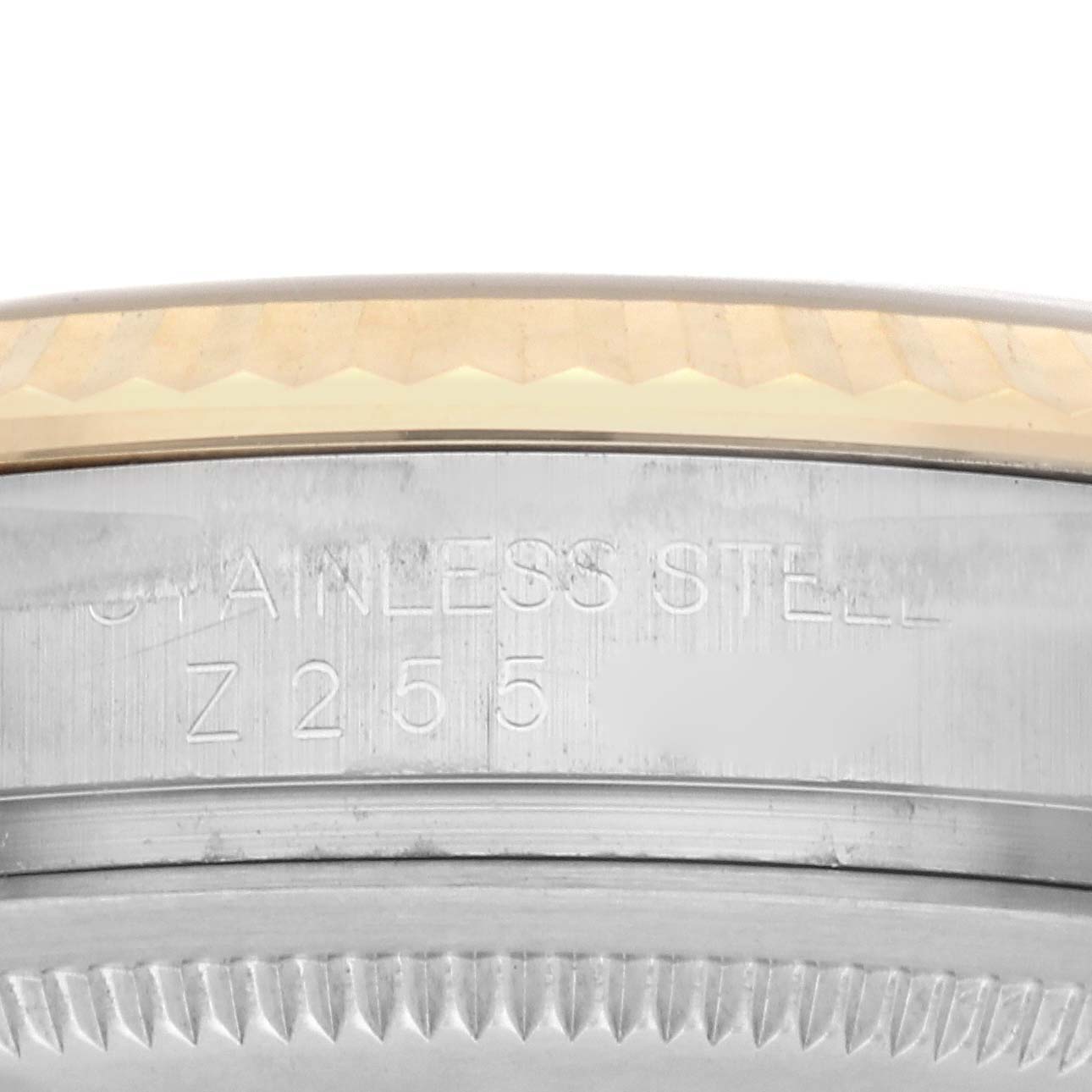 The image shows a close-up of the side of a Rolex Datejust 116233 Men
s Steel and Gold (two tone) Champagne Dial 116233 Men
s Steel and Gold (two tone) Champagne Dial watch, focusing on the stainless steel bezel and engraved details.