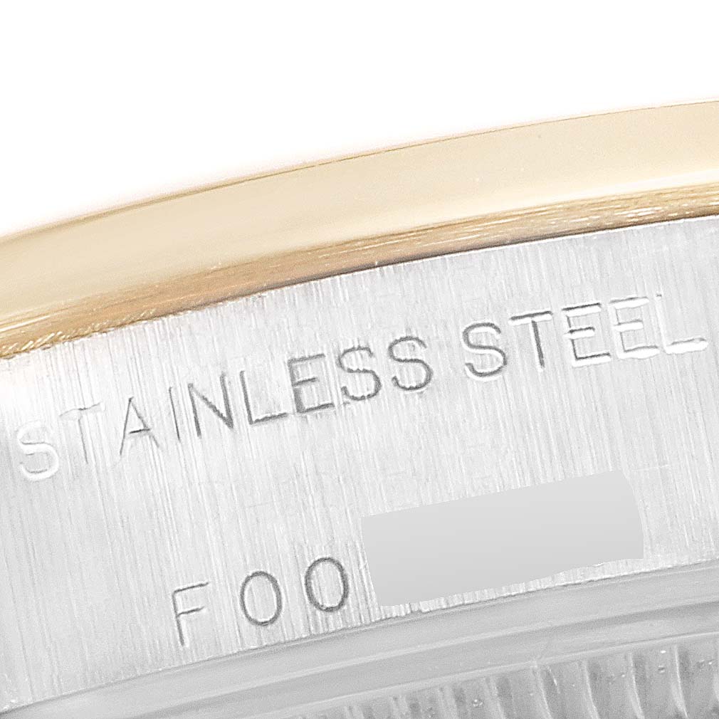 This close-up image of a Rolex Datejust 79163 Women's Steel and Gold (two tone) Silver Dial 79163 Women's Steel and Gold (two tone) Silver Dial watch shows the case side with "STAINLESS STEEL" and part of the model number engraved.