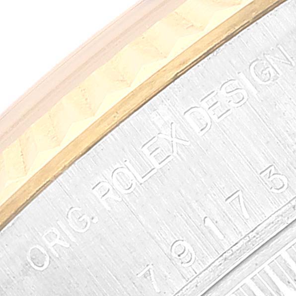 The image shows a close-up, angled view of the engraved text on the side of a Rolex Datejust 79173 Women's Steel and Gold (two tone) Blue Dial 79173 Women's Steel and Gold (two tone) Blue Dial watch case.