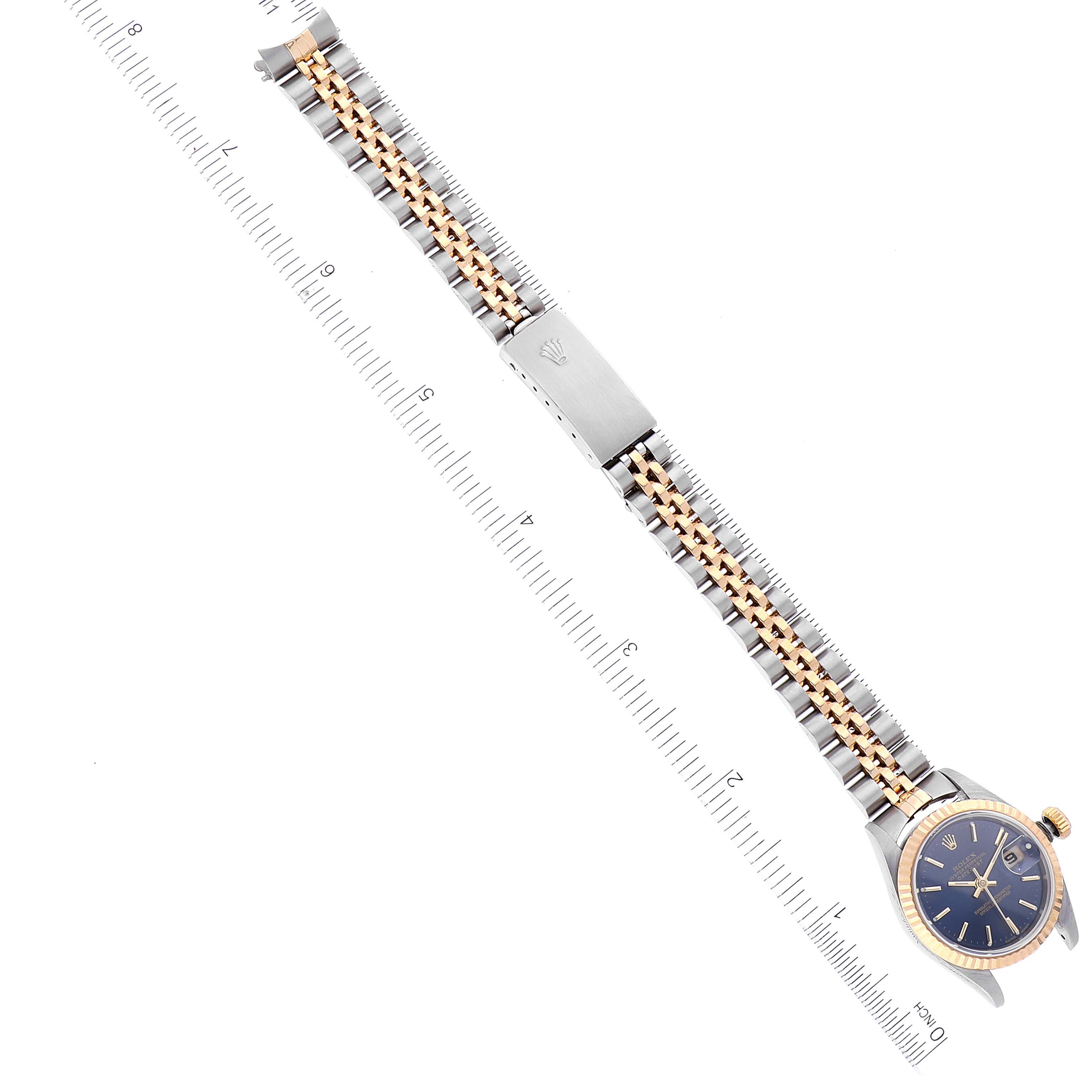The Rolex Datejust 79173 Women's Steel and Gold (two tone) Blue Dial 79173 Women's Steel and Gold (two tone) Blue Dial watch is shown from a top-down angle, displaying its face, bracelet, and clasp alongside a measurement scale.