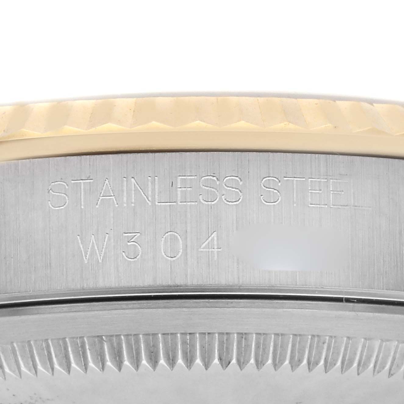 The image shows a close-up of the side engraving on a Rolex Datejust 16233 Men's Steel and Gold (two tone) Grey Dial 16233 Men's Steel and Gold (two tone) Grey Dial watch, highlighting "STAINLESS STEEL" and a serial number.