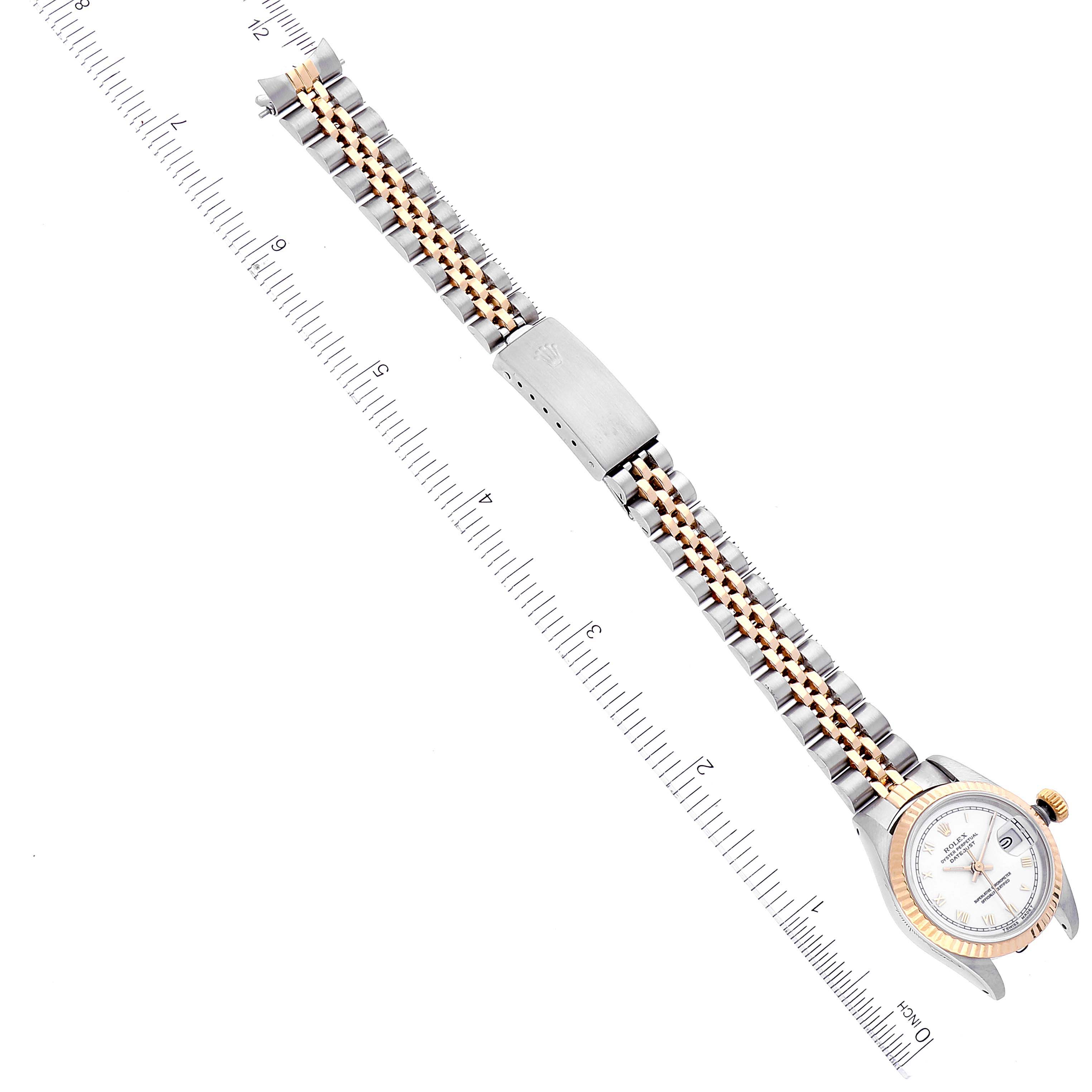 This image shows a top-down view of a Rolex Datejust 69173 Women's Steel and Gold (two tone) White Dial 69173 Women's Steel and Gold (two tone) White Dial watch with a two-tone band and a measuring scale beside it.