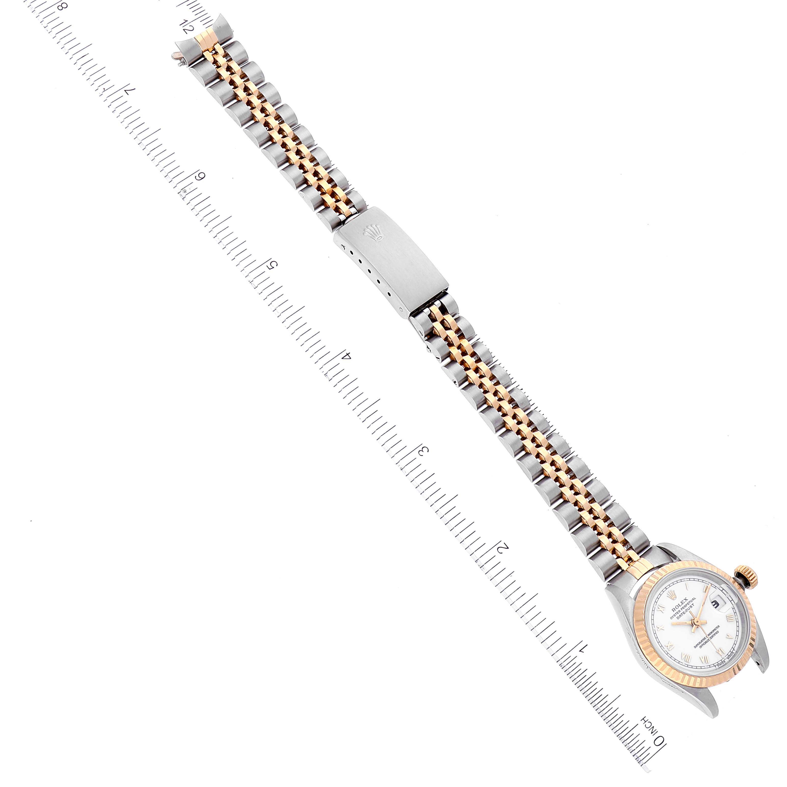 The image shows an overhead view of a Rolex Datejust 69173 Women's Steel and Gold (two tone) White Dial 69173 Women's Steel and Gold (two tone) White Dial watch, highlighting its bracelet and clasp, with a ruler for scale.