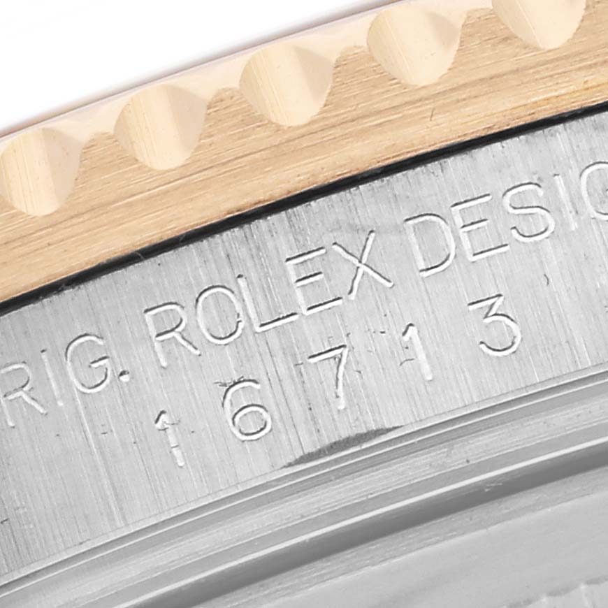 This close-up image shows the engraved side of the bezel and case back edge of a Rolex GMT-Master 16713 Men's Steel and Gold (two tone) Brown Dial 16713 Men's Steel and Gold (two tone) Brown Dial, model number 16713.