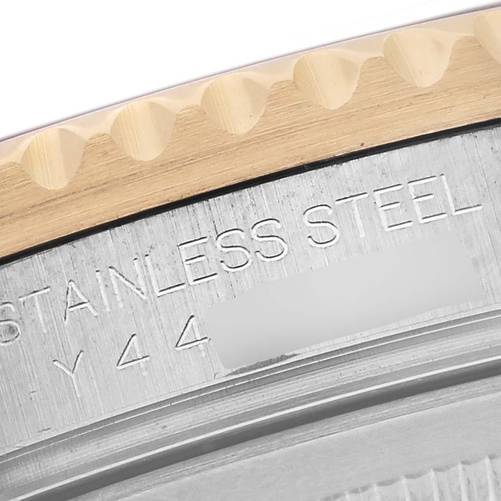 The image shows a close-up of the case back and edge of the bezel of a Rolex GMT-Master 16713 Men's Steel and Gold (two tone) Brown Dial 16713 Men's Steel and Gold (two tone) Brown Dial, highlighting the stainless steel and engraved text.