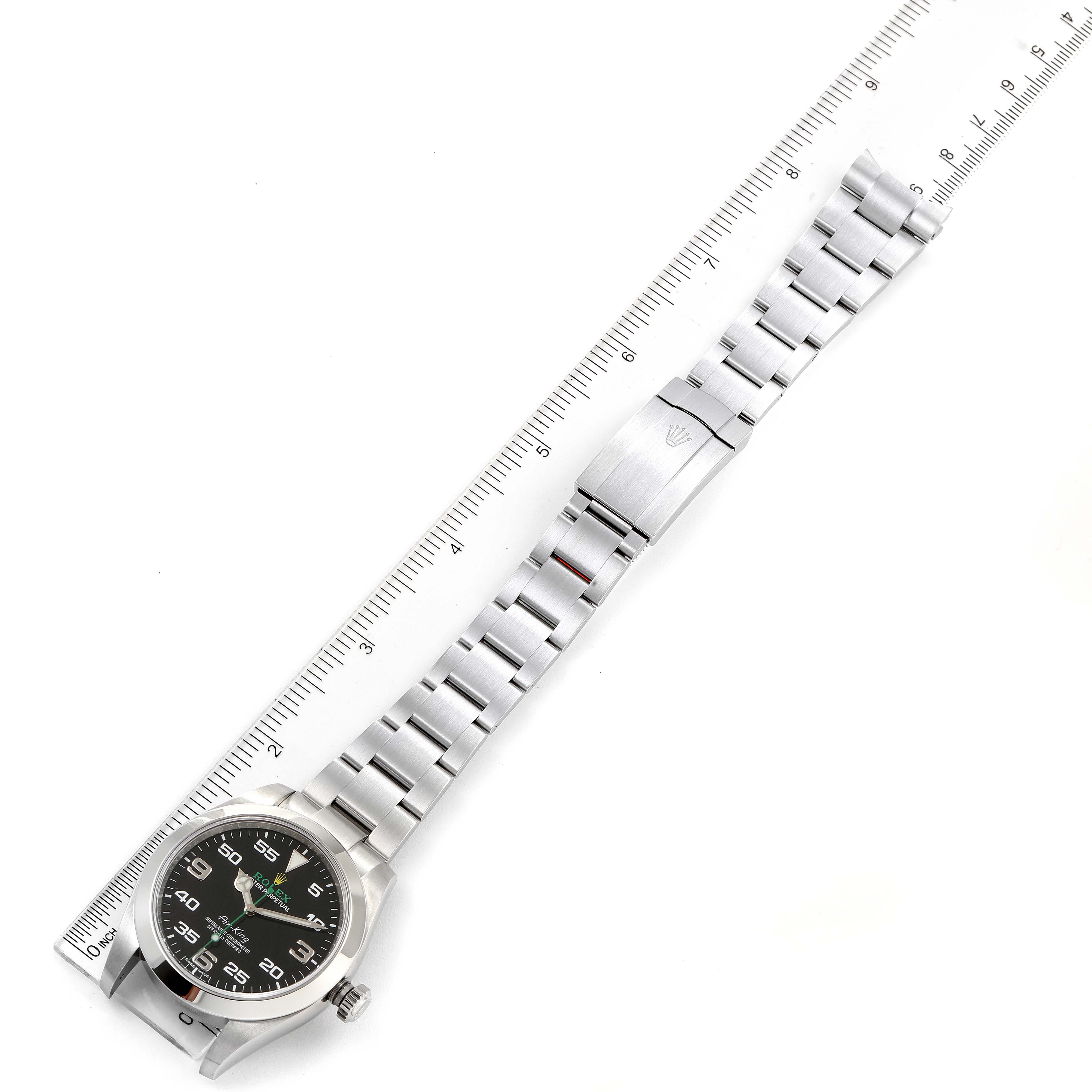 The Rolex Air-King 116900 Men's Stainless Steel Black Dial 116900 Men's Stainless Steel Black Dial watch is displayed flat from above, showing the face, bracelet, and clasp next to a ruler for size reference.