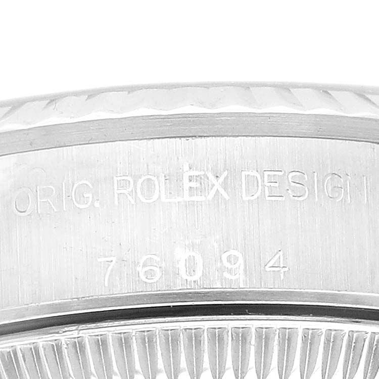 The image shows a close-up of the engraved side and bezel edge of a Rolex Oyster Perpetual 76094 Women's Stainless Steel Blue Dial 76094 Women's Stainless Steel Blue Dial watch.