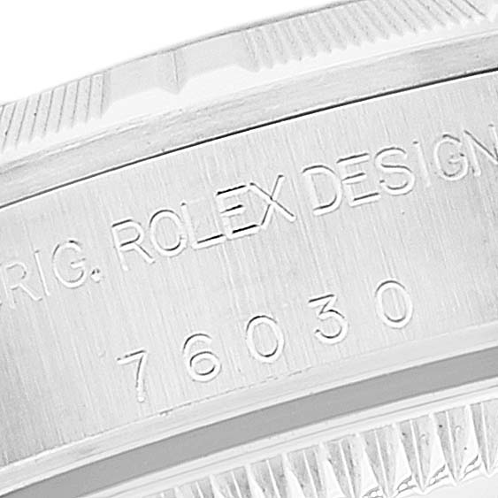 This image shows a close-up of the case side and bezel of a Rolex Oyster Perpetual 76030 Women's Stainless Steel Black Dial 76030 Women's Stainless Steel Black Dial watch, showing engraved text and part of the bezel detail.