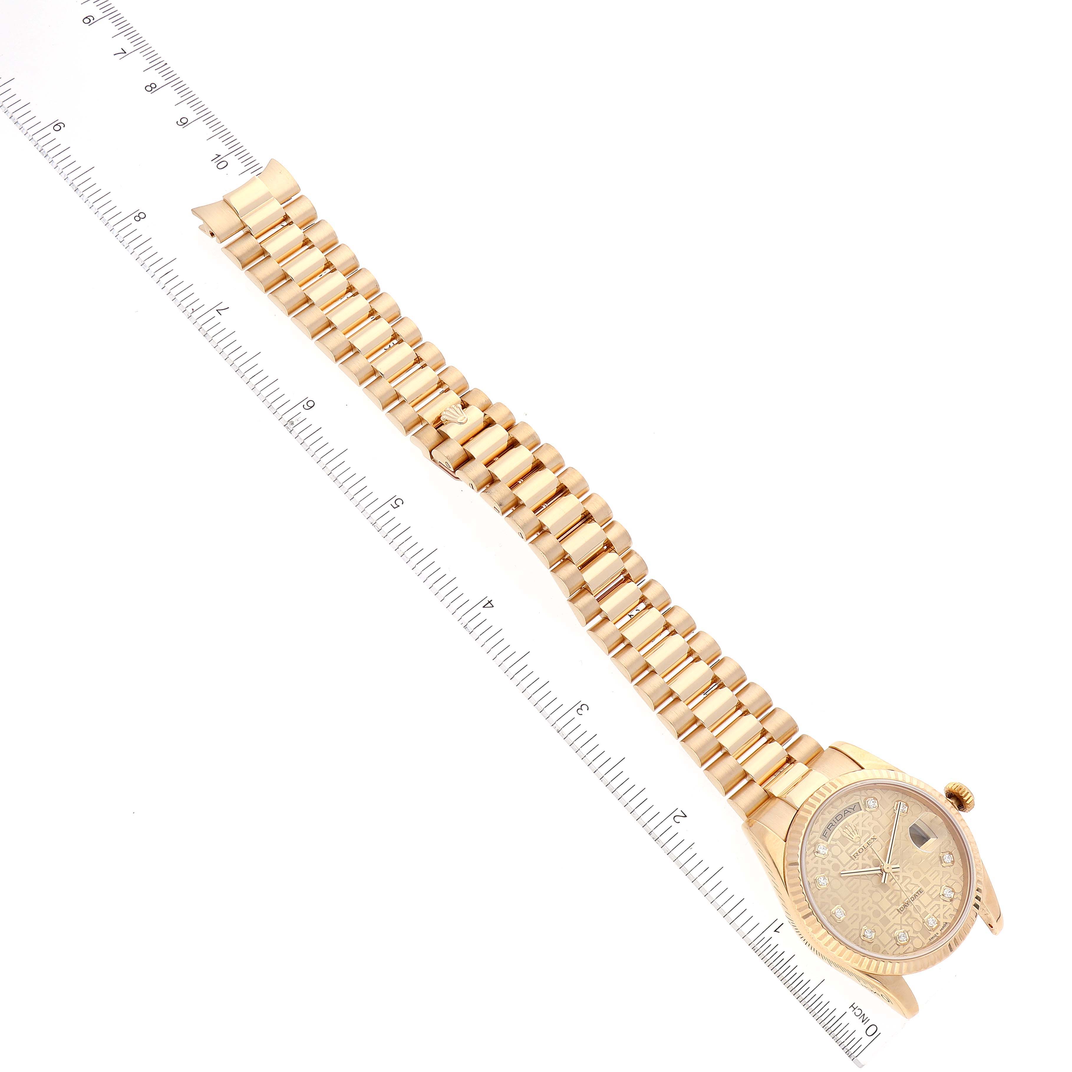 The image shows a President model Rolex watch laid flat, highlighting the full length of the band and the face, with a ruler alongside for scale.