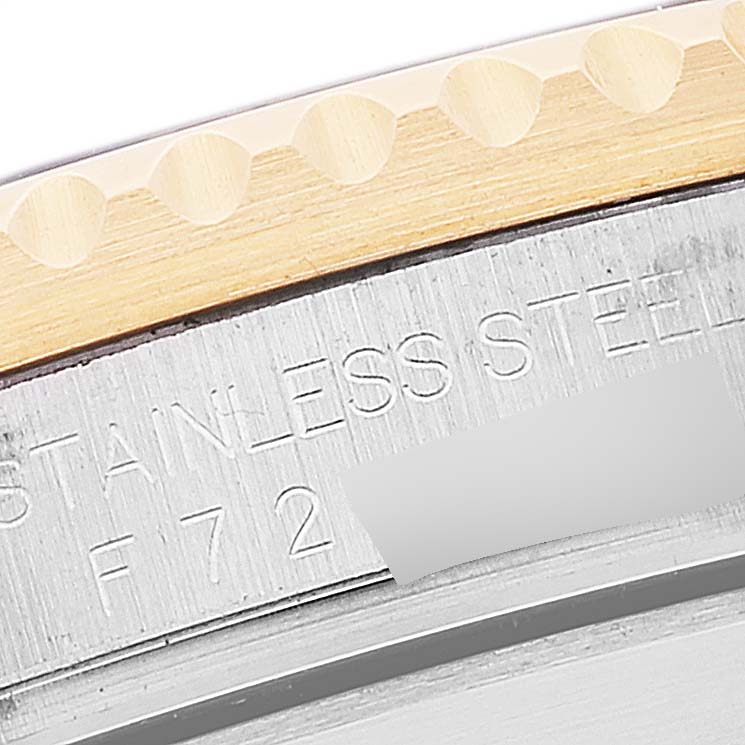 This close-up shows the engraving on the side of a Rolex Submariner 16613 Men's Steel and Gold (two tone) Blue Dial 16613 Men's Steel and Gold (two tone) Blue Dial model watch's case, including text and part of the bezel.