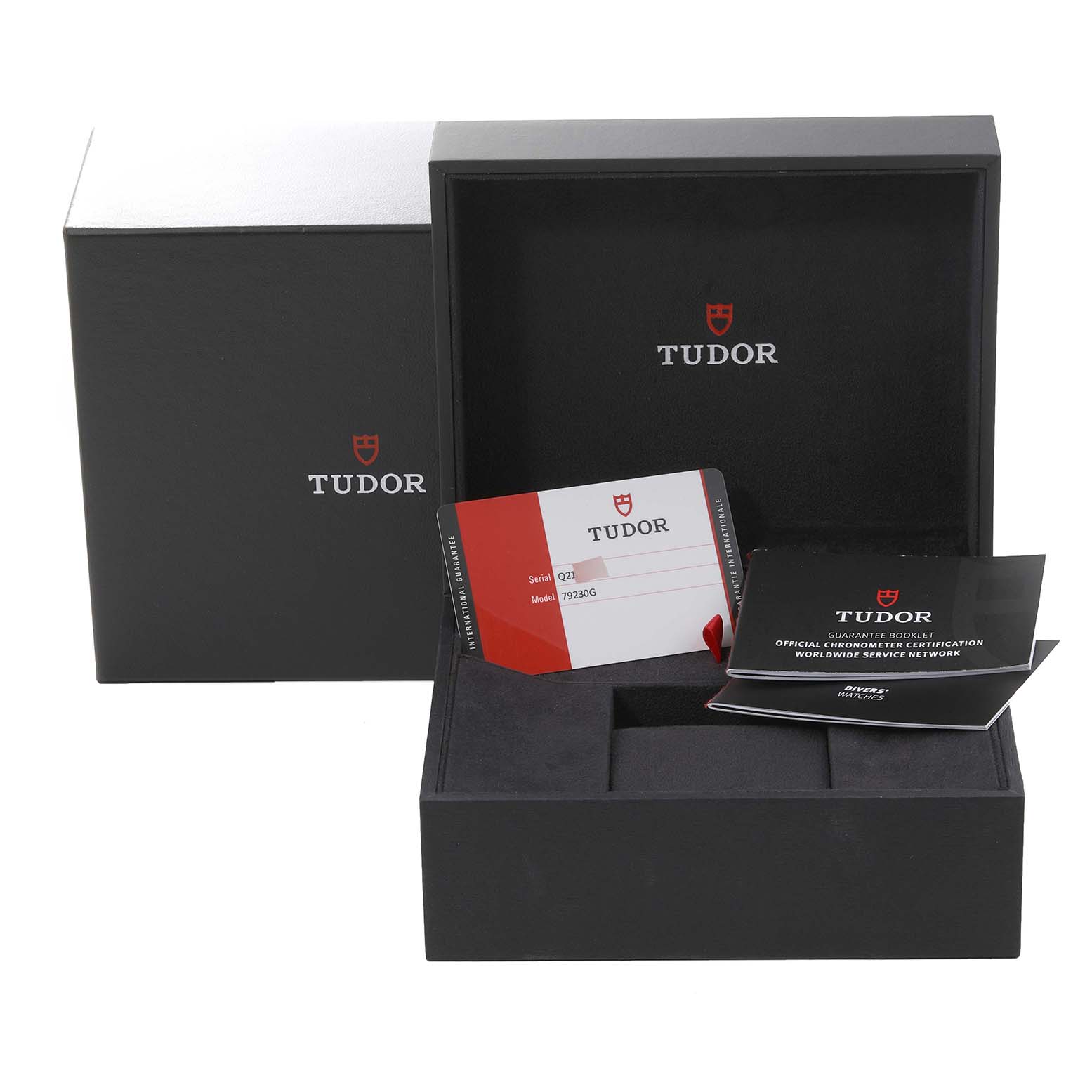 The image shows the open box for a Tudor Heritage Black Bay 79230G Men
s Stainless Steel Black Dial 79230G Men
s Stainless Steel Black Dial watch, including the warranty card and instruction booklets.