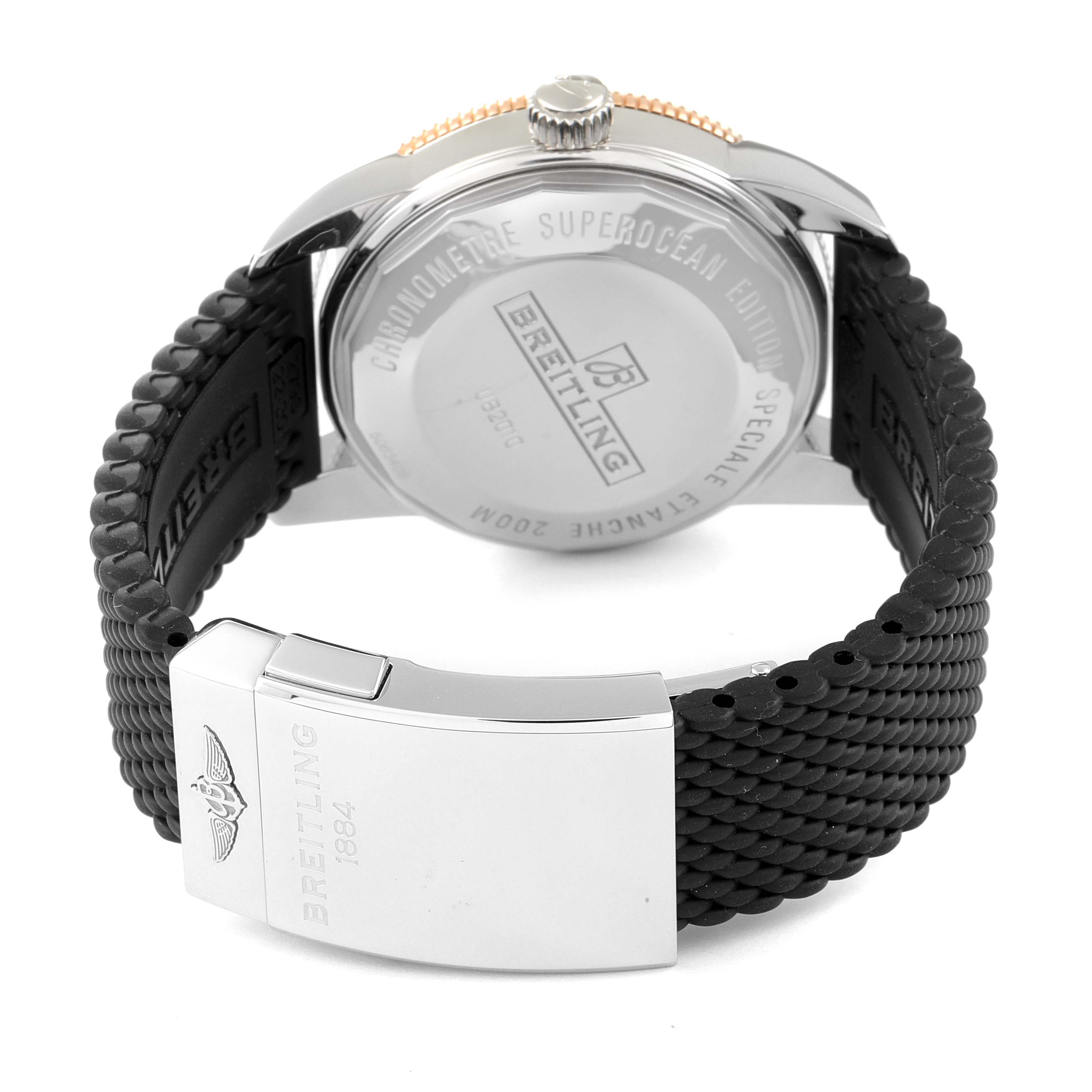 This image shows the back case and clasp area of a Breitling Superocean UB201012/BG53/154A Men's Steel and Gold (two tone) Black Dial UB201012/BG53/154A Men's Steel and Gold (two tone) Black Dial watch, including the engraved case back and rubber strap.