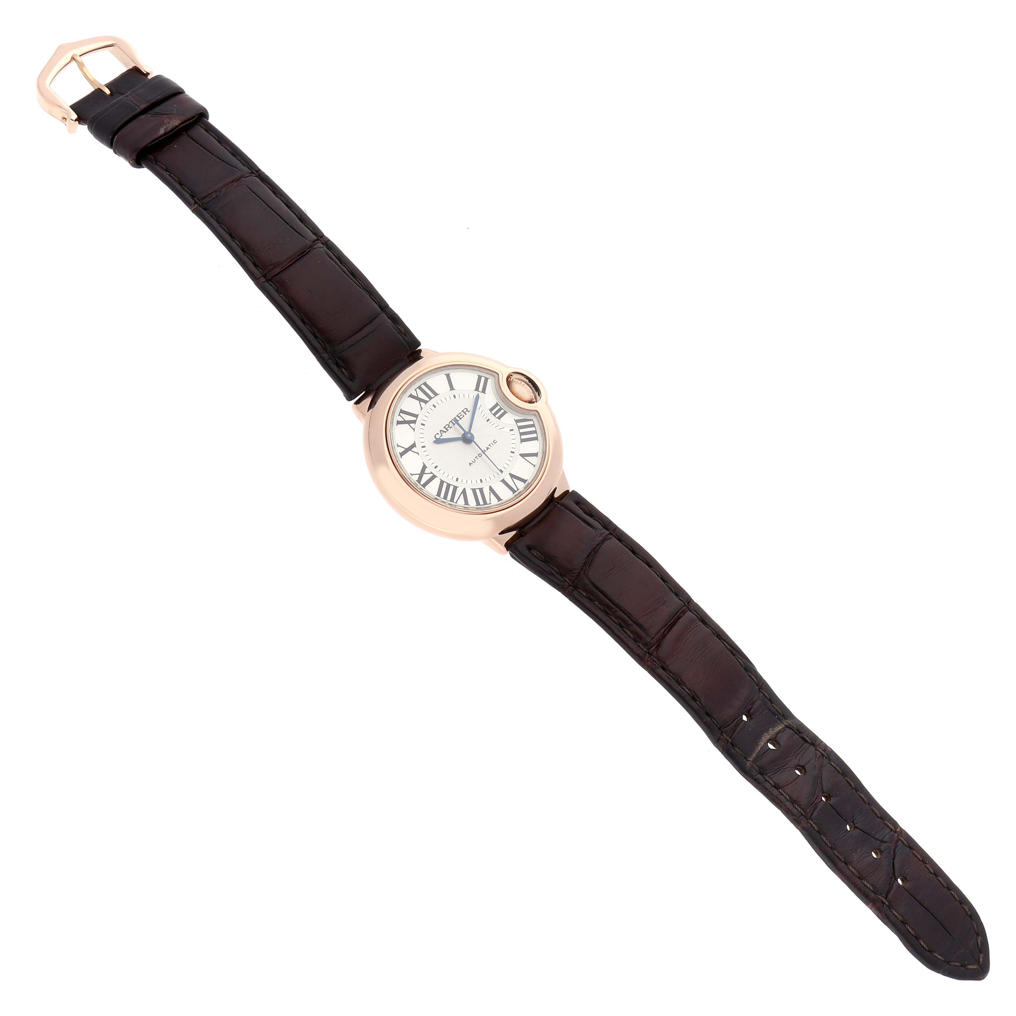 The Cartier Ballon Bleu W6920097 Women's Rose Gold Silver Dial watch is shown from a top-down angle, displaying the watch face and leather strap.