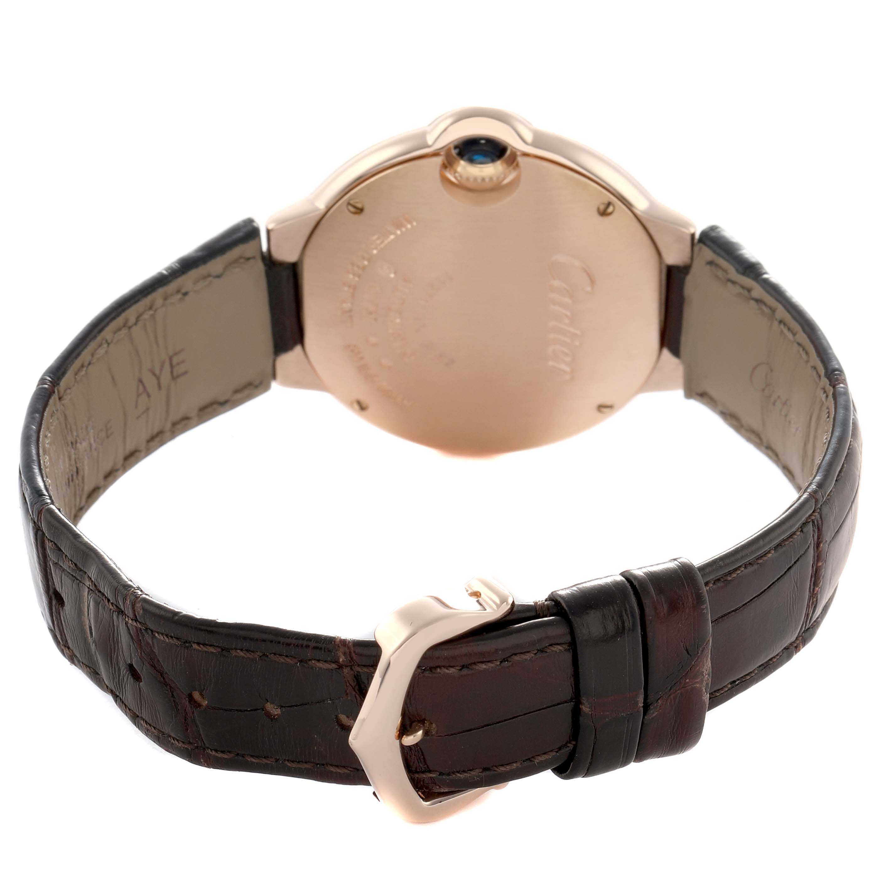 The Cartier Ballon Bleu W6920097 Women's Rose Gold Silver Dial watch is shown from the back, highlighting its case back, brown leather strap, and clasp.