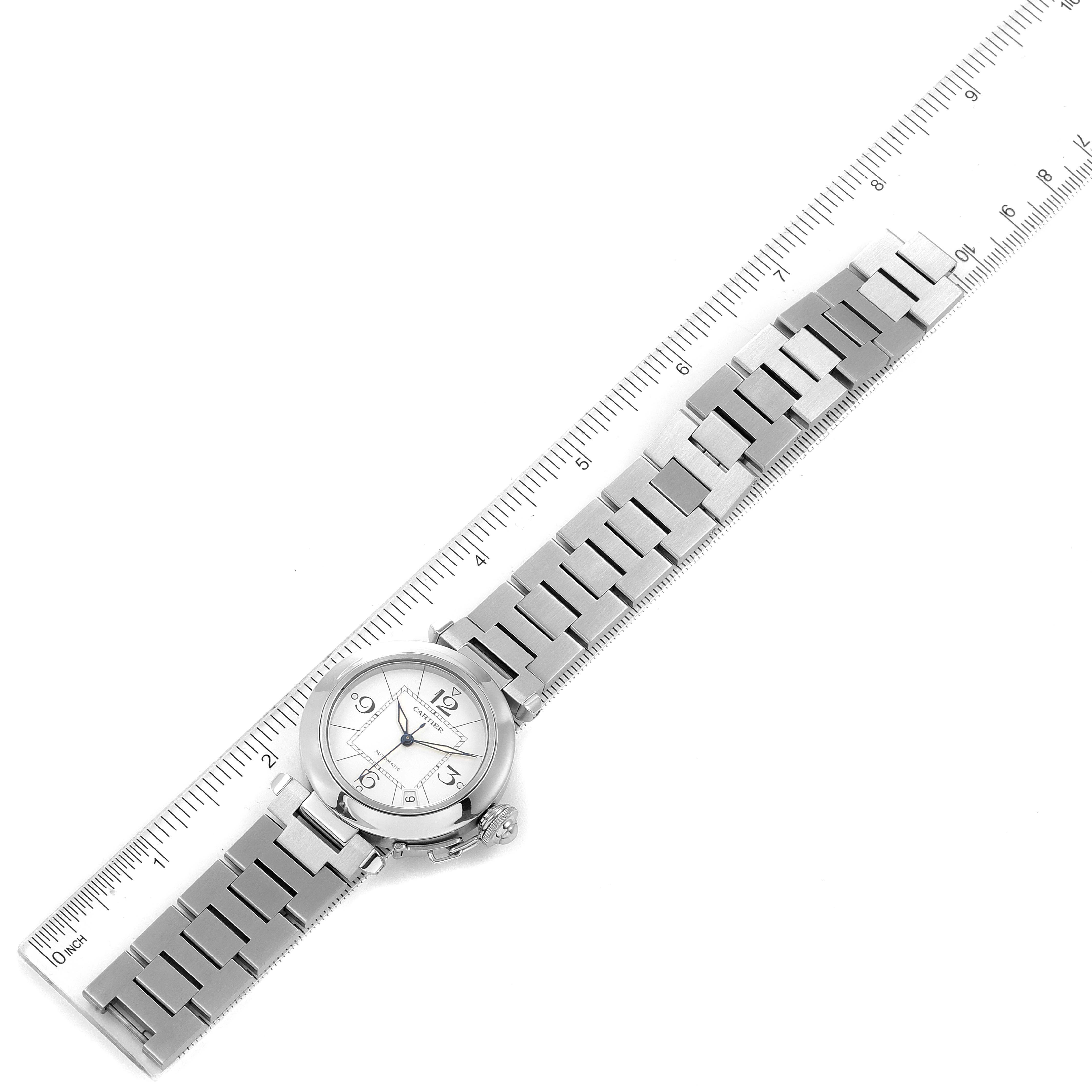 The image shows a top-down view of a Cartier Pasha W31074M7 Women's Stainless Steel White Dial W31074M7 Women's Stainless Steel White Dial model watch with its metal bracelet laid flat next to a ruler.