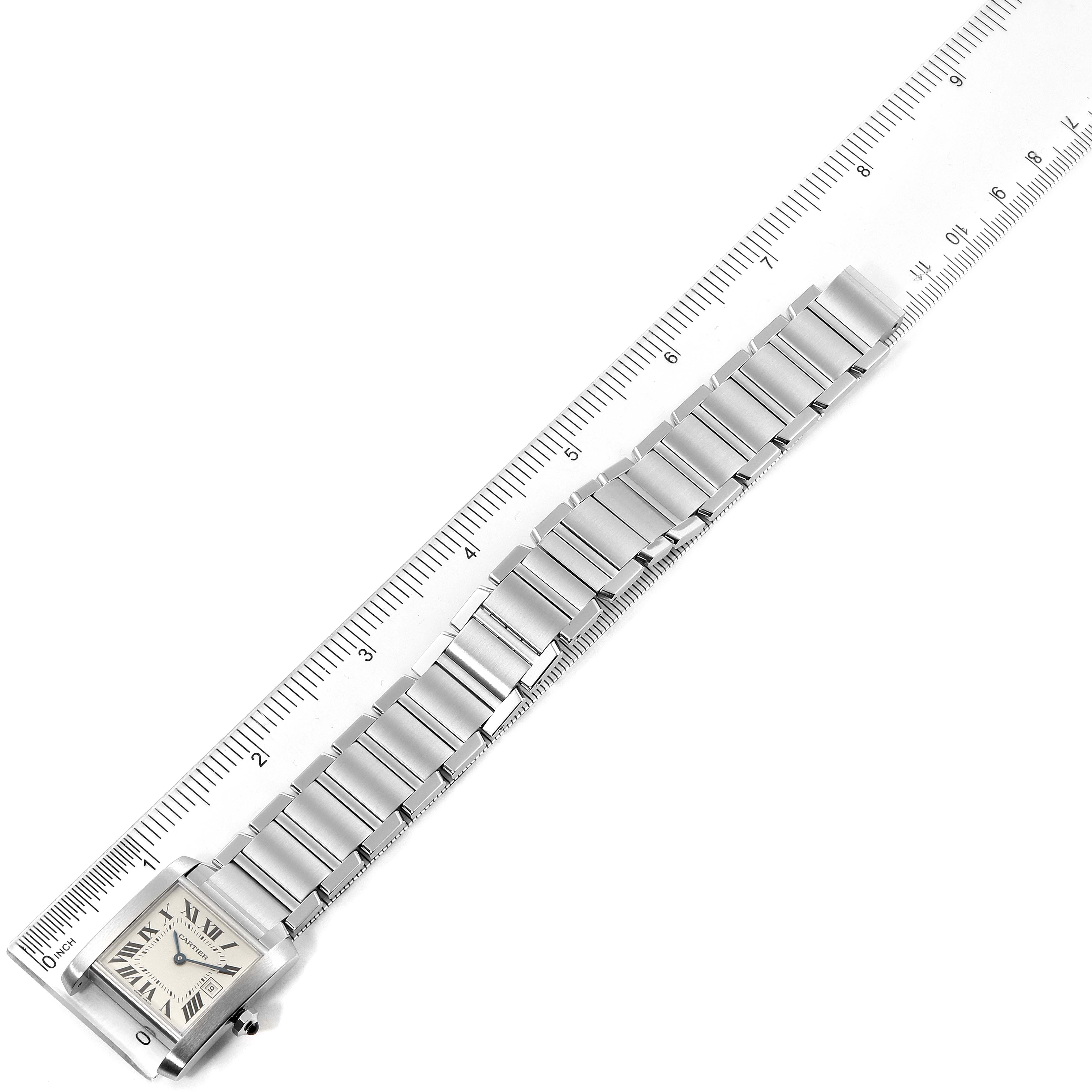 The image shows a Cartier Tank Francaise W51011Q3 Women
s Stainless Steel Silver Dial W51011Q3 Women
s Stainless Steel Silver Dial watch laid flat next to a ruler, displaying the band and part of the face.
