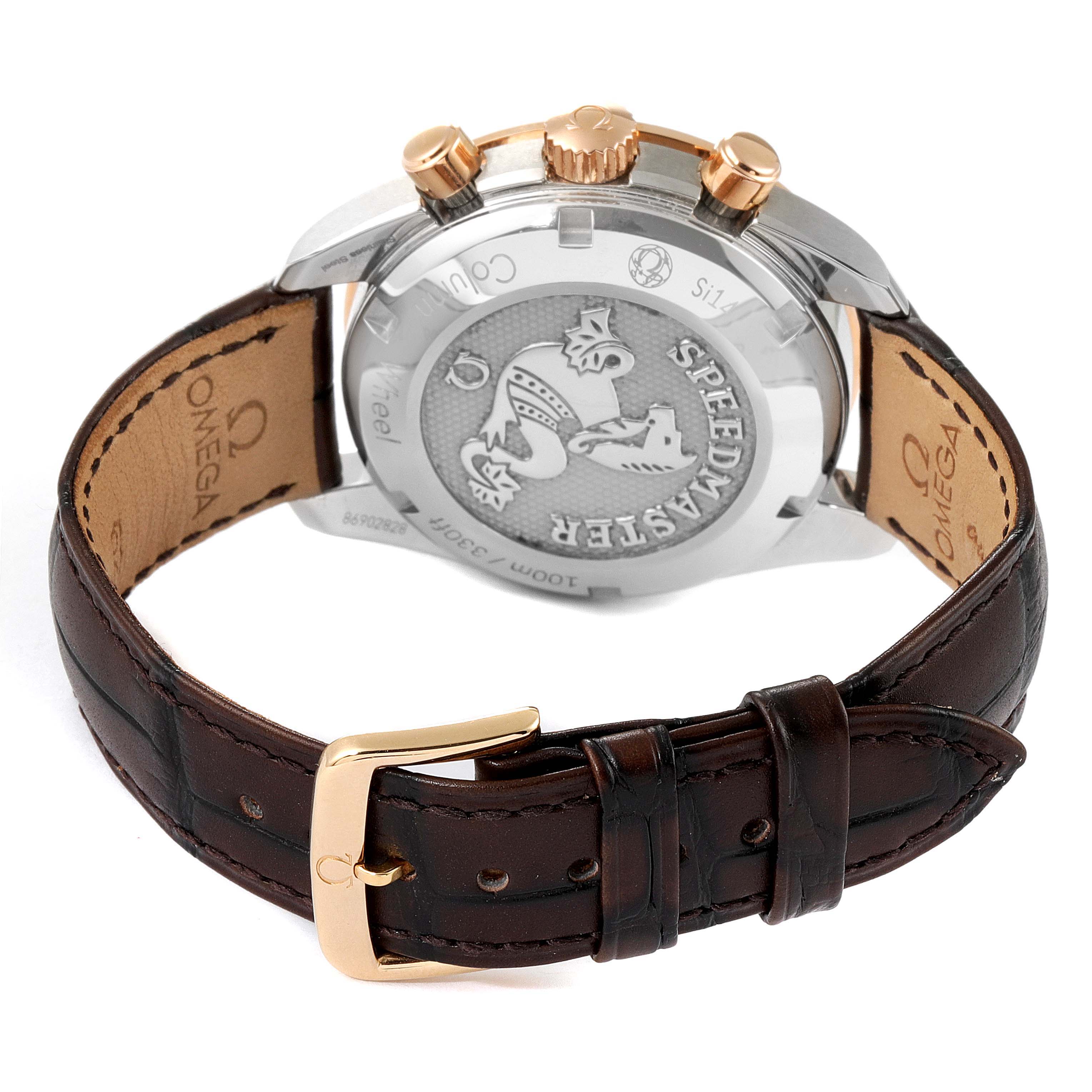 The image shows the back view of the Omega Speedmaster 324.23.38.50.02.002 Men's Steel and Gold (two tone) Silver Dial 324.23.38.50.02.002 Men's Steel and Gold (two tone) Silver Dial watch and its brown leather strap with a gold buckle.