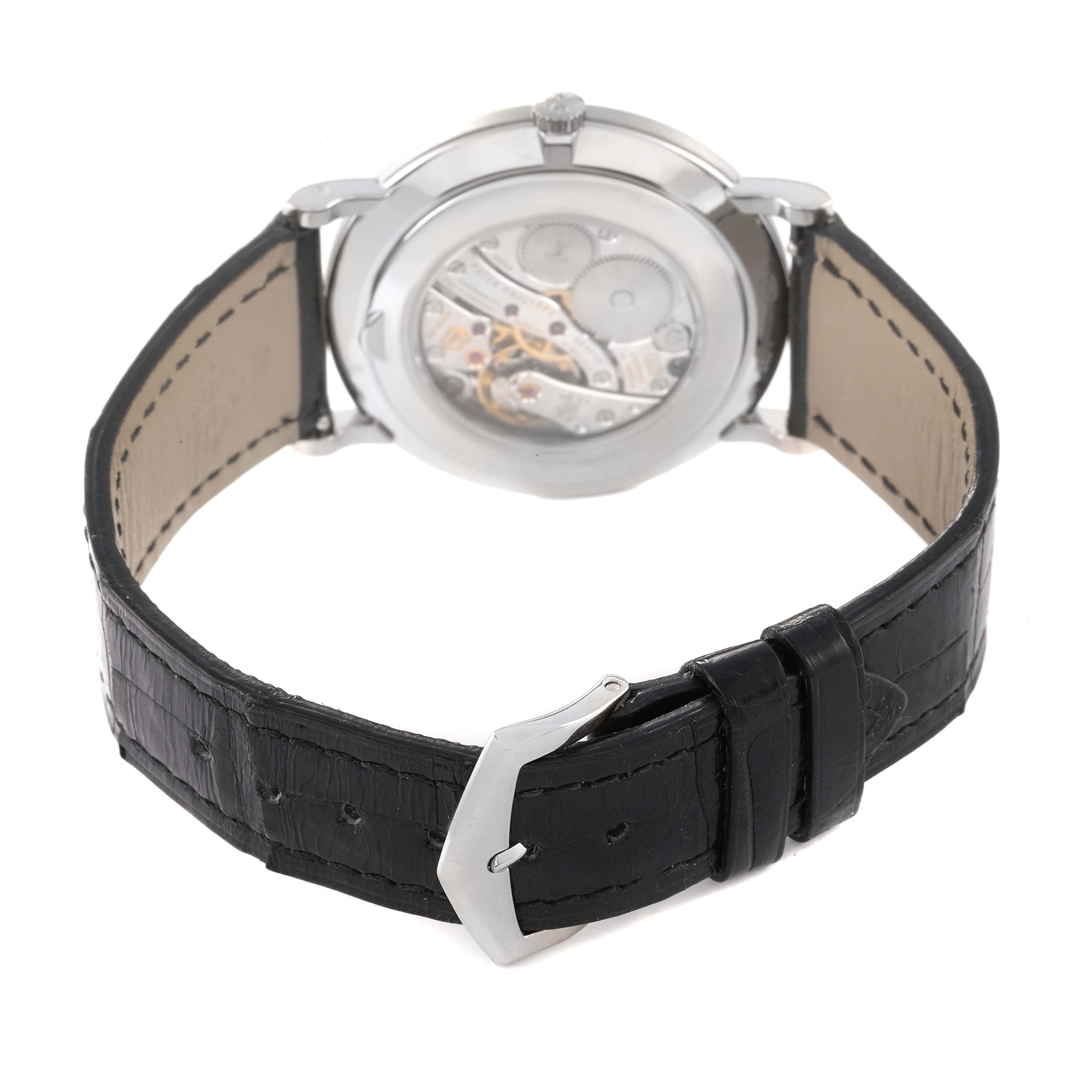 The image shows the back view of a Patek Philippe Calatrava 5119G Men's White Gold White Dial 5119G Men's White Gold White Dial watch, highlighting the movement and the black leather strap with buckle.