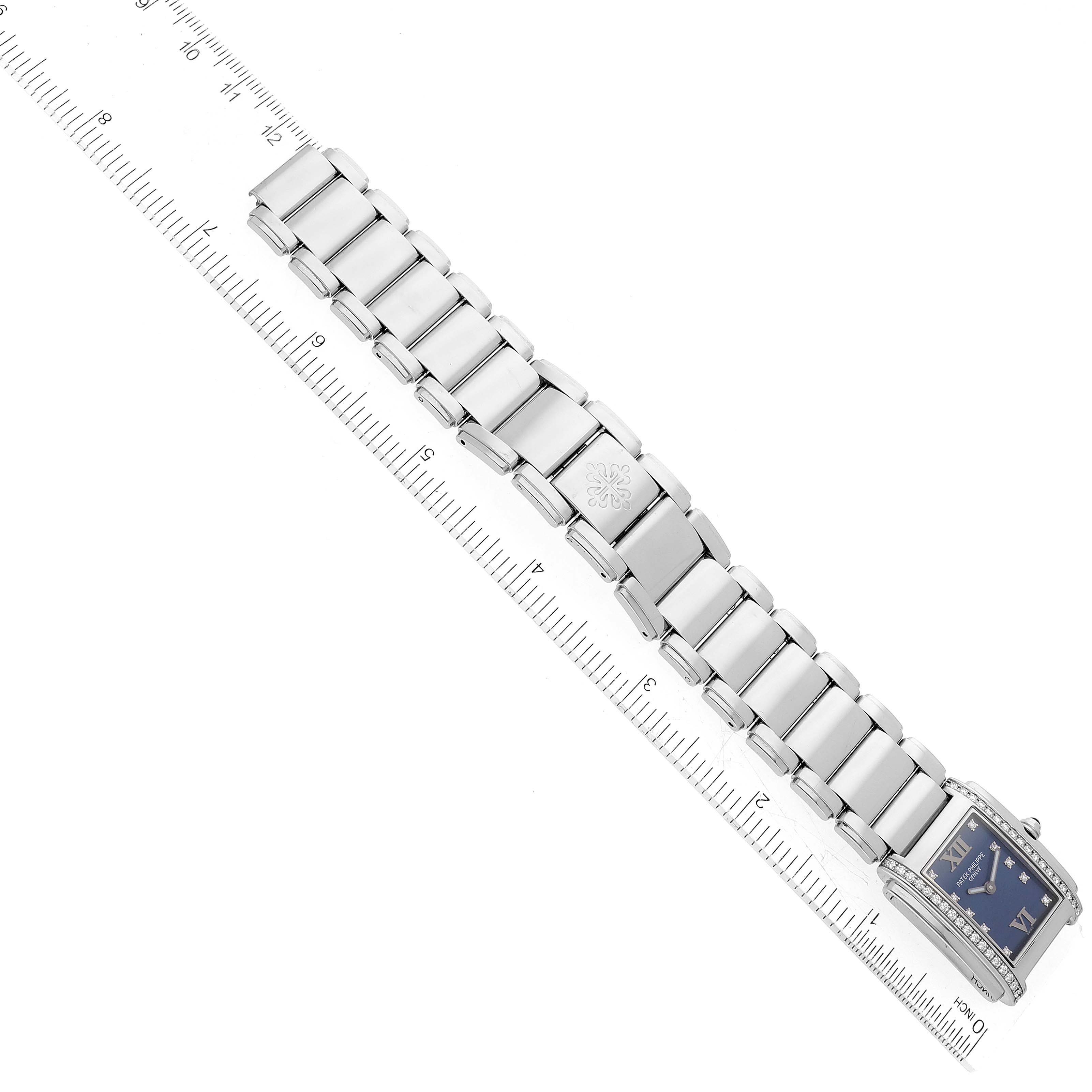 The Patek Philippe Twenty-4 4910/10A-012 Women's Stainless Steel Blue Dial 4910/10A-012 Women's Stainless Steel Blue Dial watch is shown from an overhead angle, featuring the watch face and the entire metal bracelet alongside a ruler for scale.
