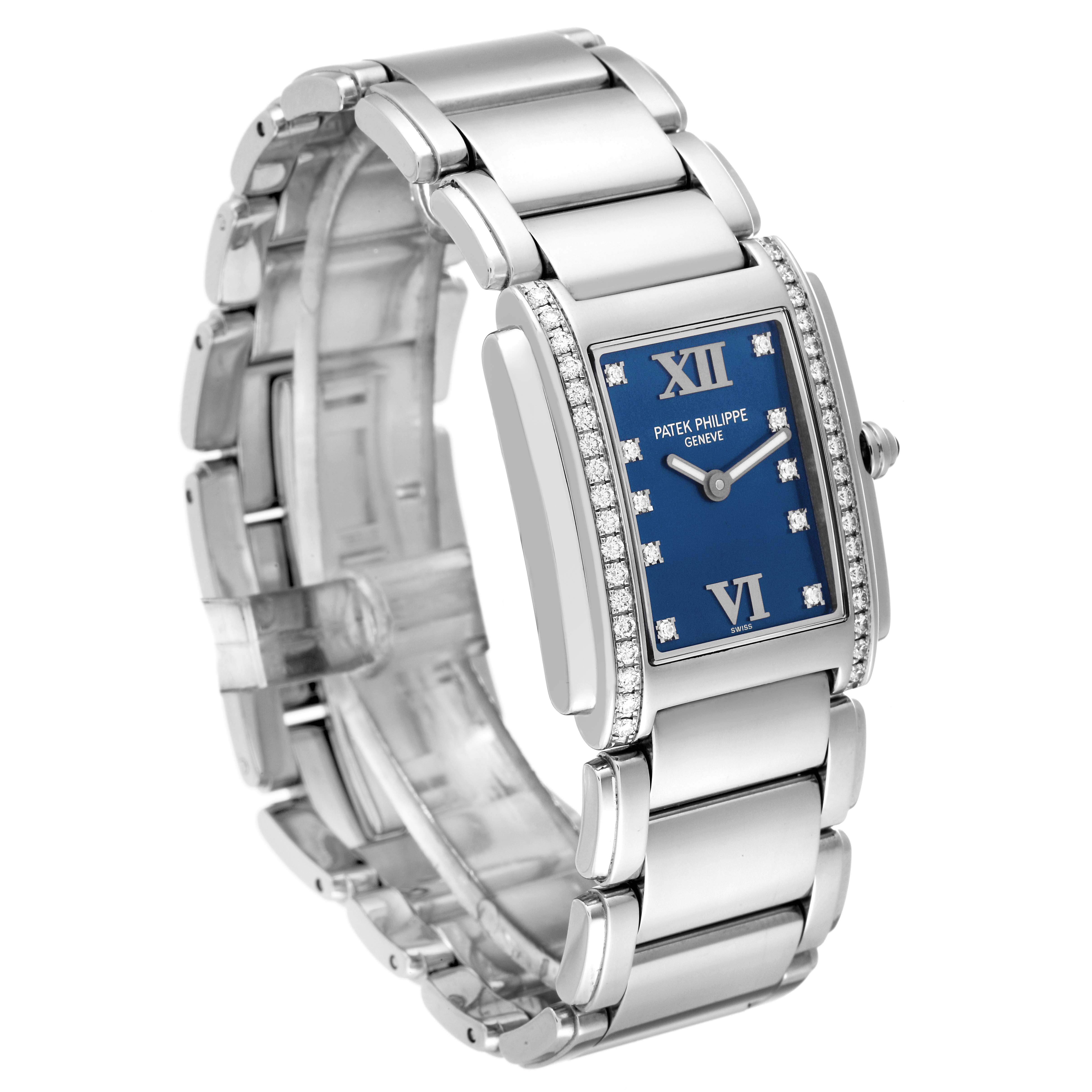 The image shows a side angle of the Patek Philippe Twenty-4 4910/10A-012 Women's Stainless Steel Blue Dial 4910/10A-012 Women's Stainless Steel Blue Dial watch, focusing on its blue dial, diamond bezel, and metal bracelet.
