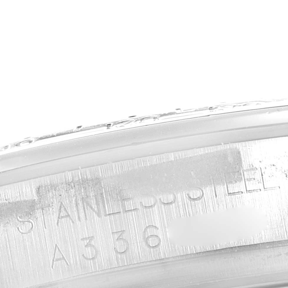 This image shows a close-up of the side of a stainless steel case of a Rolex Daytona 16520 Men's Stainless Steel Black Dial 16520 Men's Stainless Steel Black Dial watch with some serial information engraved.