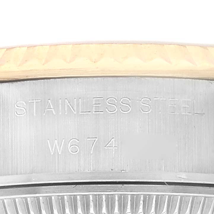 The image shows an engraved serial number and "STAINLESS STEEL" on the side of the case back of a Rolex Datejust 69173 Women's Steel and Gold (two tone) Champagne Dial 69173 Women's Steel and Gold (two tone) Champagne Dial watch.