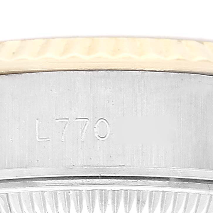 This image shows a close-up of the case side of a Rolex Datejust 69173 Women's Steel and Gold (two tone) Champagne Dial 69173 Women's Steel and Gold (two tone) Champagne Dial, including part of the bezel and serial number.