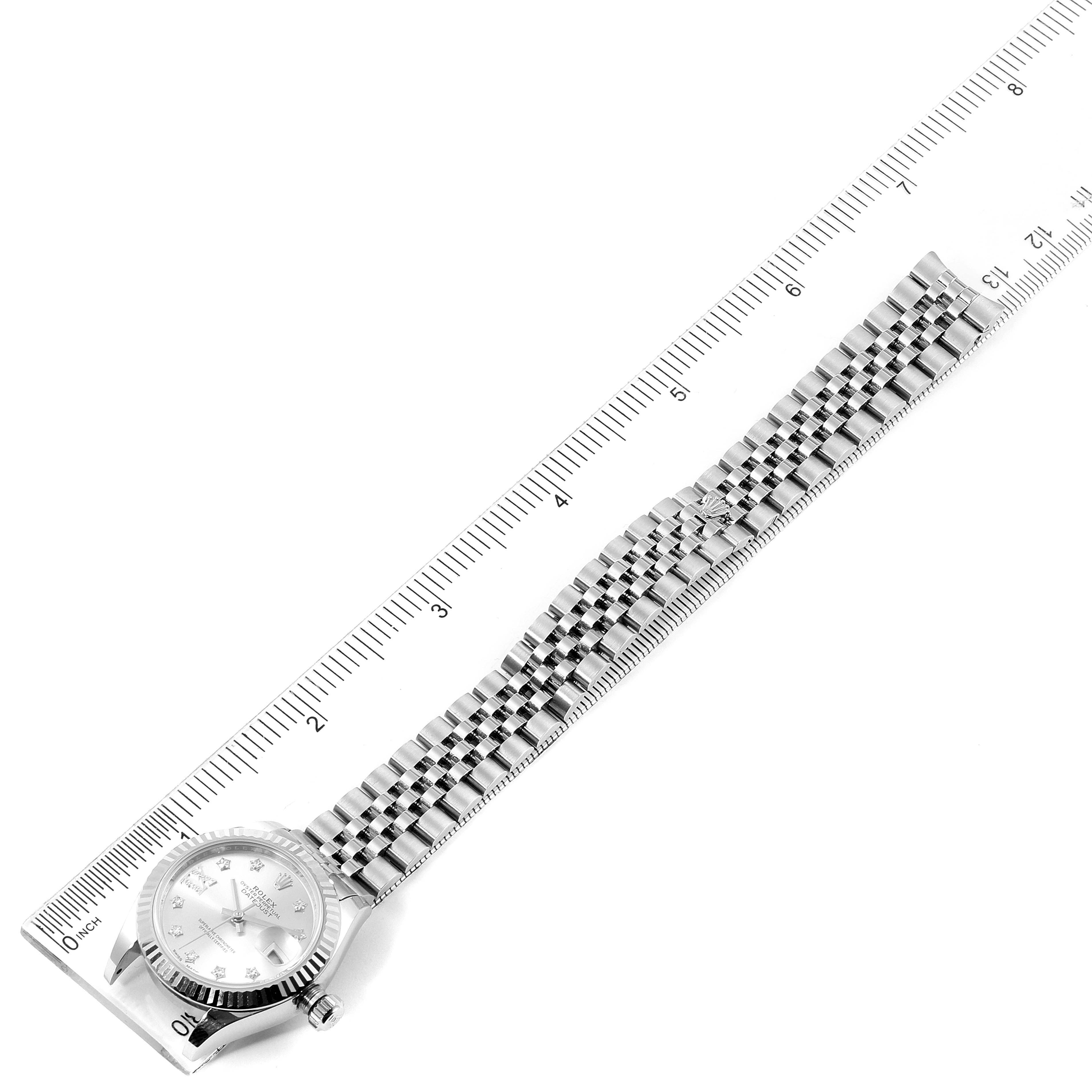 The image shows a top-down view of a Rolex Datejust 279174 Women's Stainless Steel Silver Dial 279174 Women's Stainless Steel Silver Dial watch, including its face, bezel, and full metal bracelet, placed along a ruler.