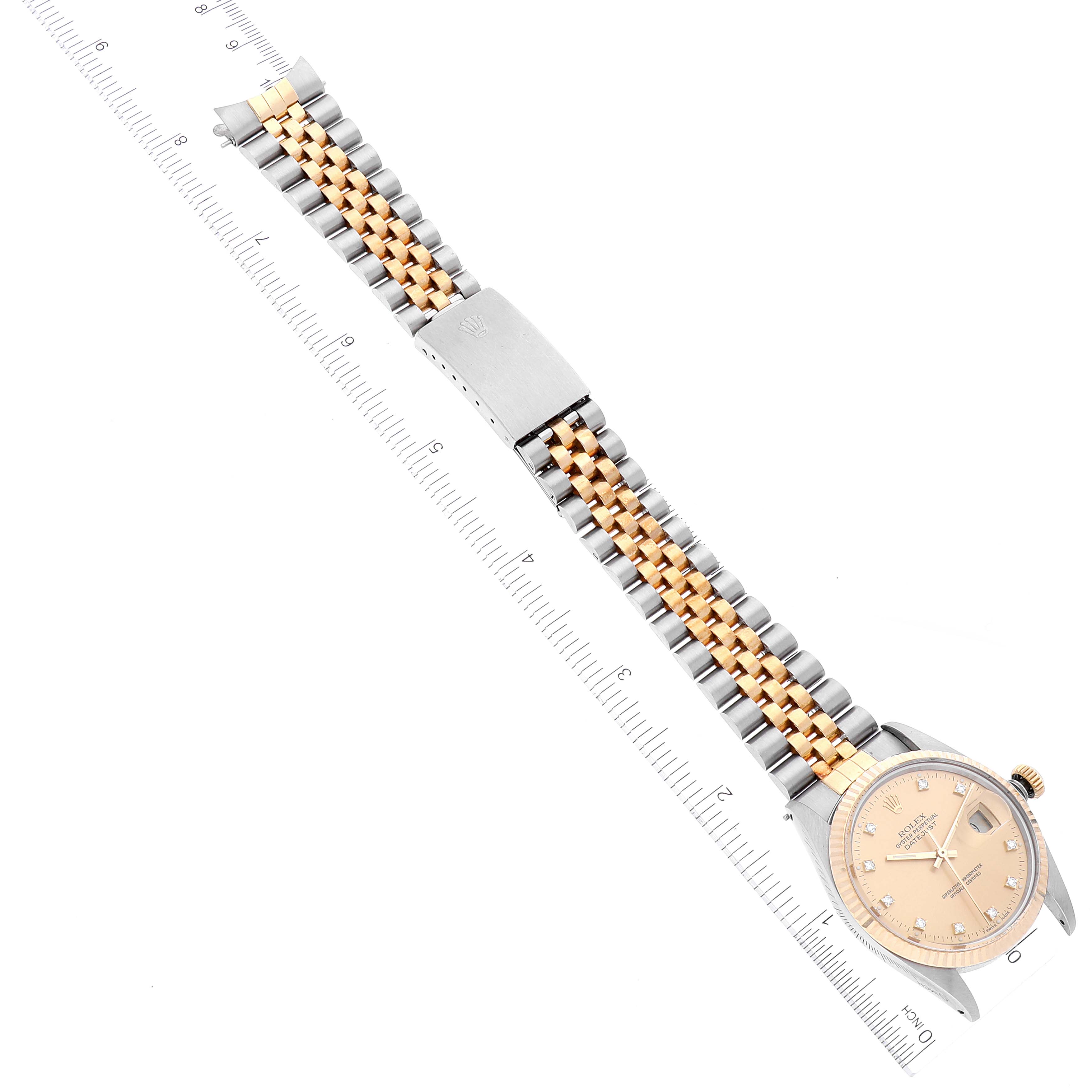 The image shows a top view of a Rolex Datejust 16013 Men's Steel and Gold (two tone) Champagne Dial 16013 Men's Steel and Gold (two tone) Champagne Dial watch, featuring its dial, case, and two-tone bracelet with a measurement ruler alongside.