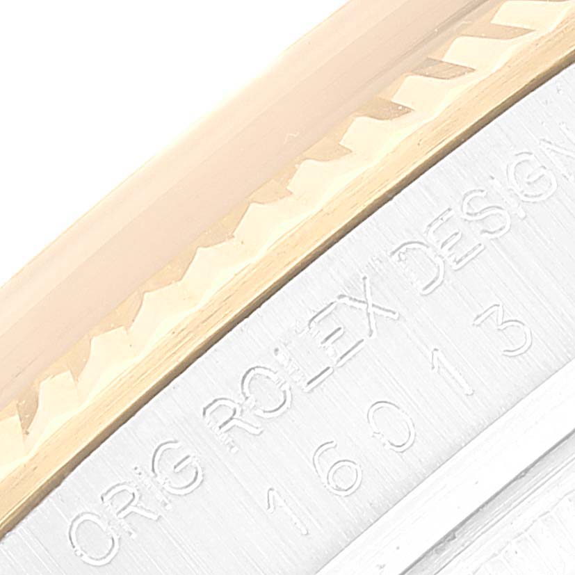 The image shows a close-up of the side of a Rolex Vintage Collection 16013 Men
s Steel and Gold (two tone) Champagne Dial 16013 Men
s Steel and Gold (two tone) Champagne Dial model, highlighting the fluted bezel and engraved text.