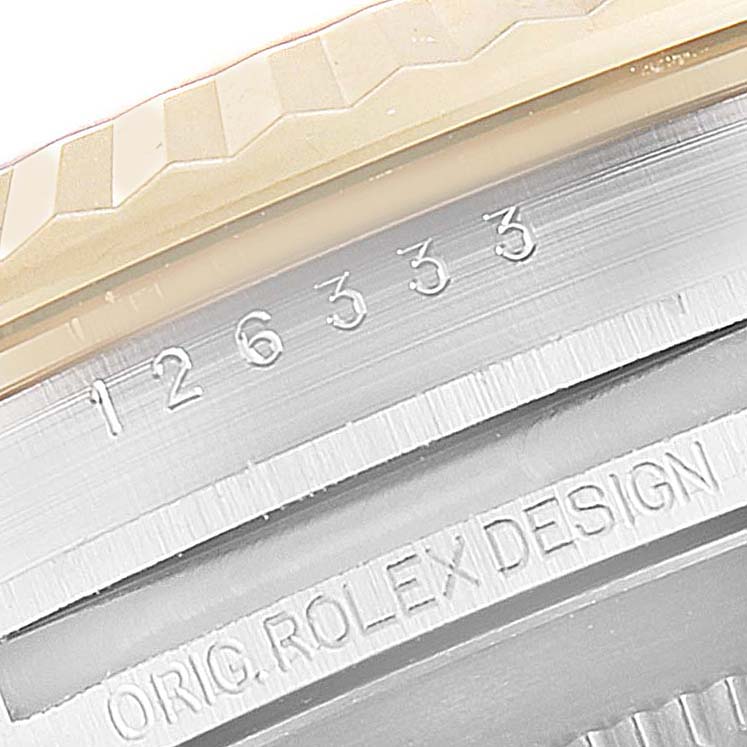 This close-up image shows the serial number and the engraving "ORIG. ROLEX DESIGN" on the casing of the Rolex Datejust 41 126333 Men's Steel and Gold (two tone) Black Dial 126333 Men's Steel and Gold (two tone) Black Dial model.