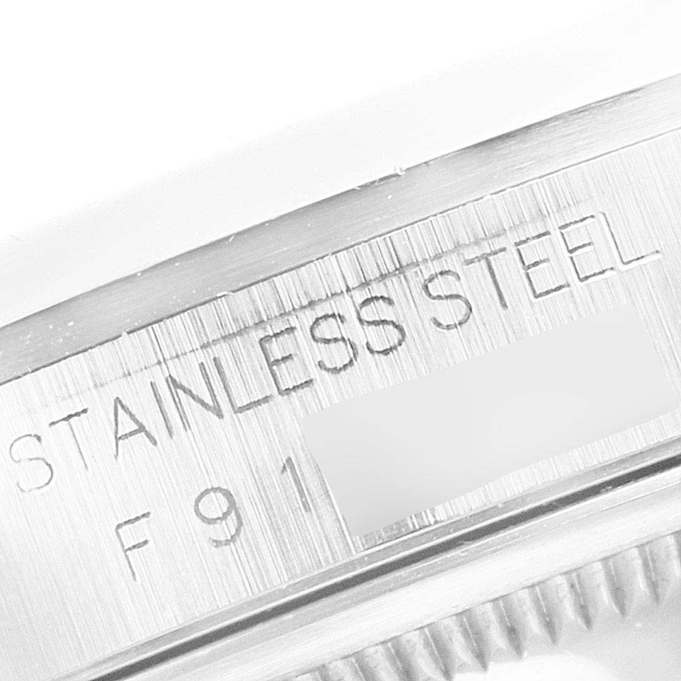 This image shows a close-up view of the stainless steel casing of a Rolex Datejust 16200 Men's Stainless Steel Black Dial 16200 Men's Stainless Steel Black Dial watch with partial text and some serial number.