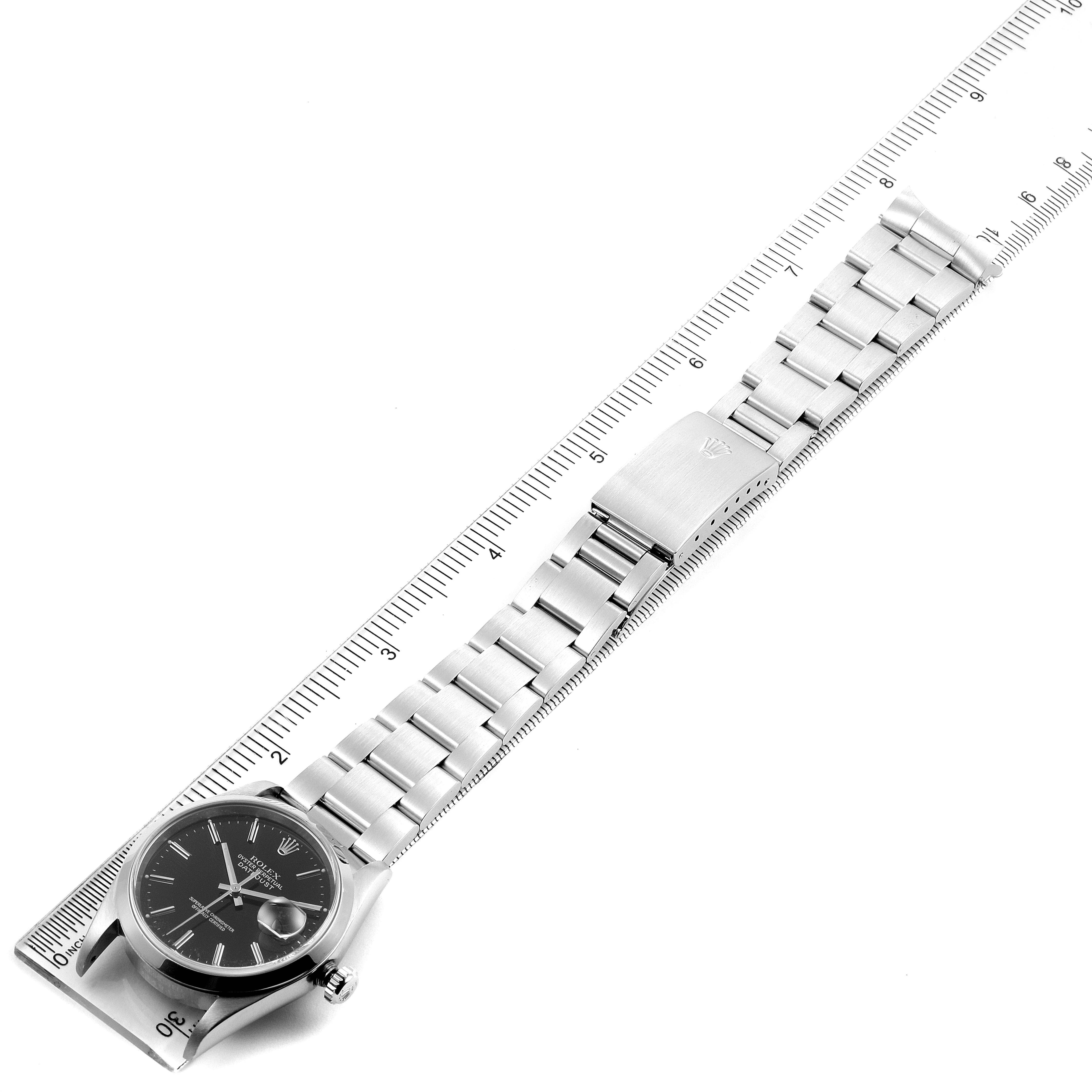 The image shows a top-down view of a Rolex Datejust 16200 Men's Stainless Steel Black Dial 16200 Men's Stainless Steel Black Dial watch with a stainless steel bracelet and clasp placed against a ruler.