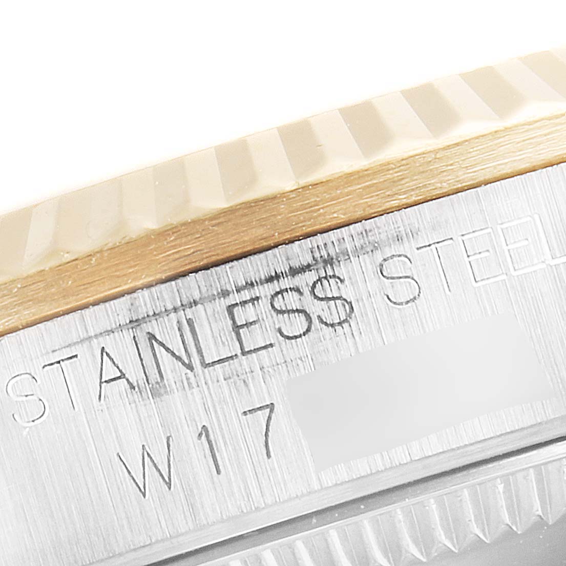 This close-up image of a mid-size Rolex watch shows part of the stainless steel case and a portion of the fluted bezel.