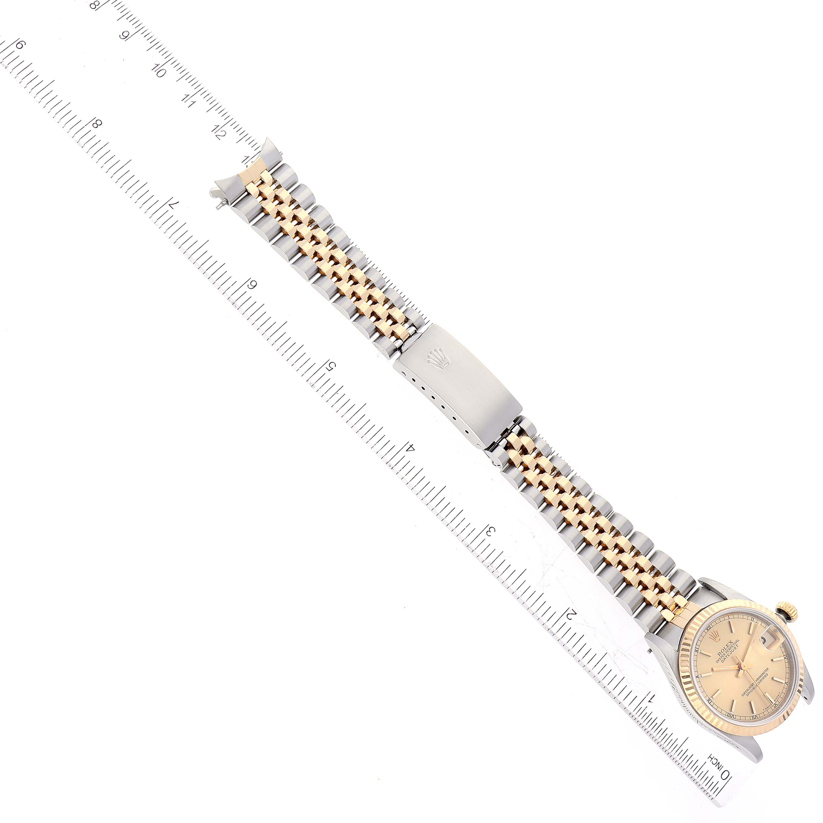 The image shows a top view of a Rolex Mid-Size 68273 Women's Steel and Gold (two tone) Champagne Dial 68273 Women's Steel and Gold (two tone) Champagne Dial watch with a ruler, highlighting the dial, bracelet, and clasp.