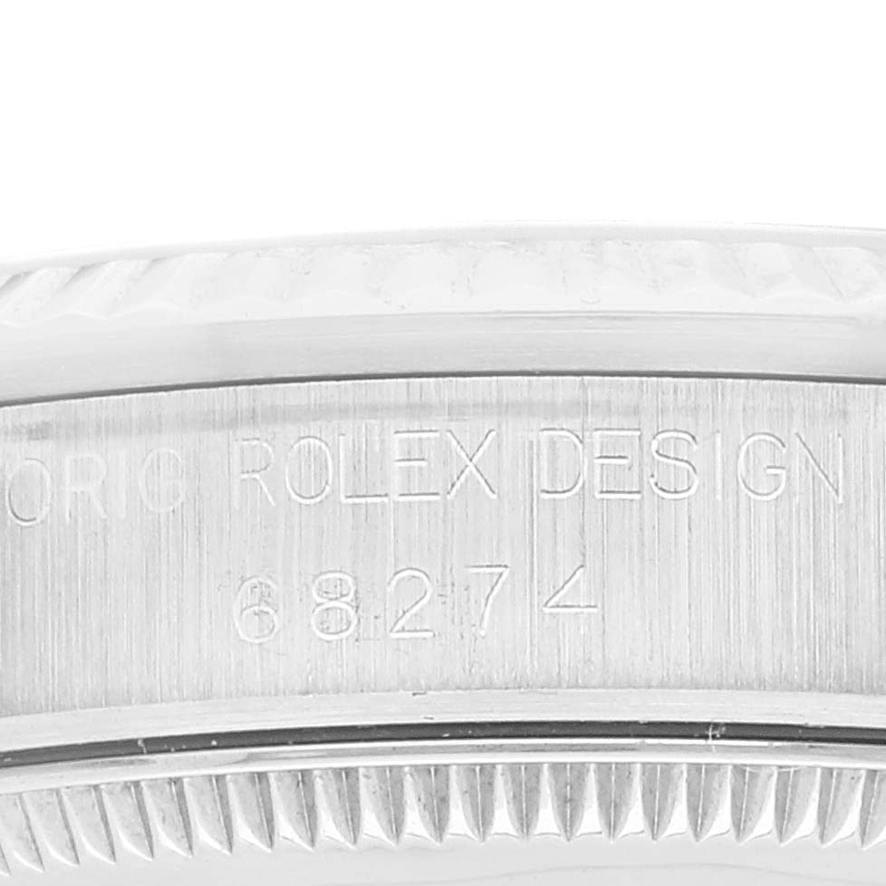 This image shows a close-up of the engraved side of the Mid-Size Rolex watch case, including part of the bezel.